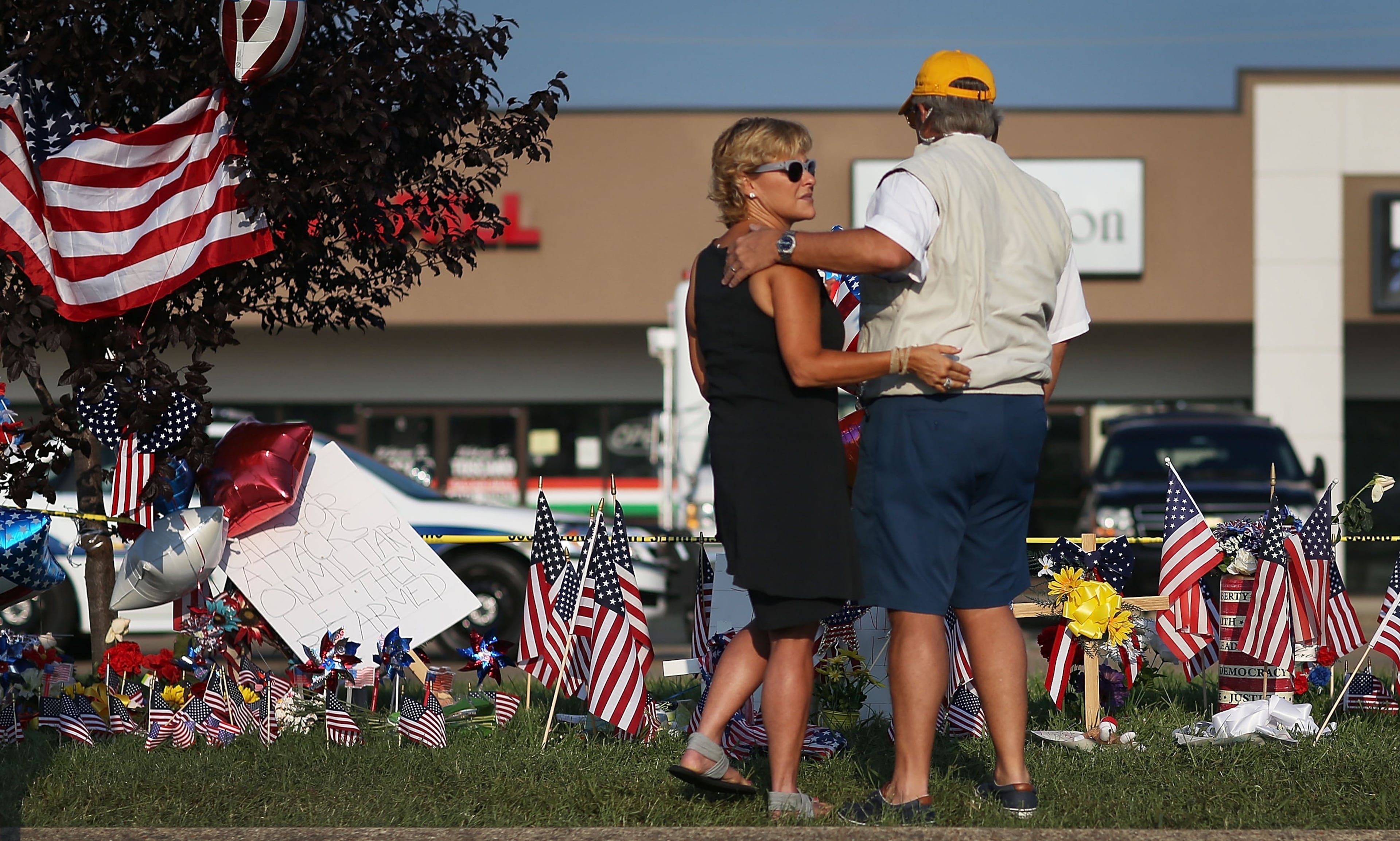 CHATTANOOGA, TN - JULY 18: People look on at a memorial setup in front of the Armed Forces Career Center/National Guard Recruitment Office which had been shot up on July 18, 2015 in Chattanooga, Tennessee. According to reports, Mohammod Youssuf Abdulazeez, 24, opened fire on the military recruiting station at the strip mall on July 16th and then drove more than seven miles away to an operational support center operated by the U.S. Navy and killed four United States Marines and a Navy sailor. The gunman was likely killed in a exchange of gunfire with the police. (Photo by Joe Raedle/Getty Images)