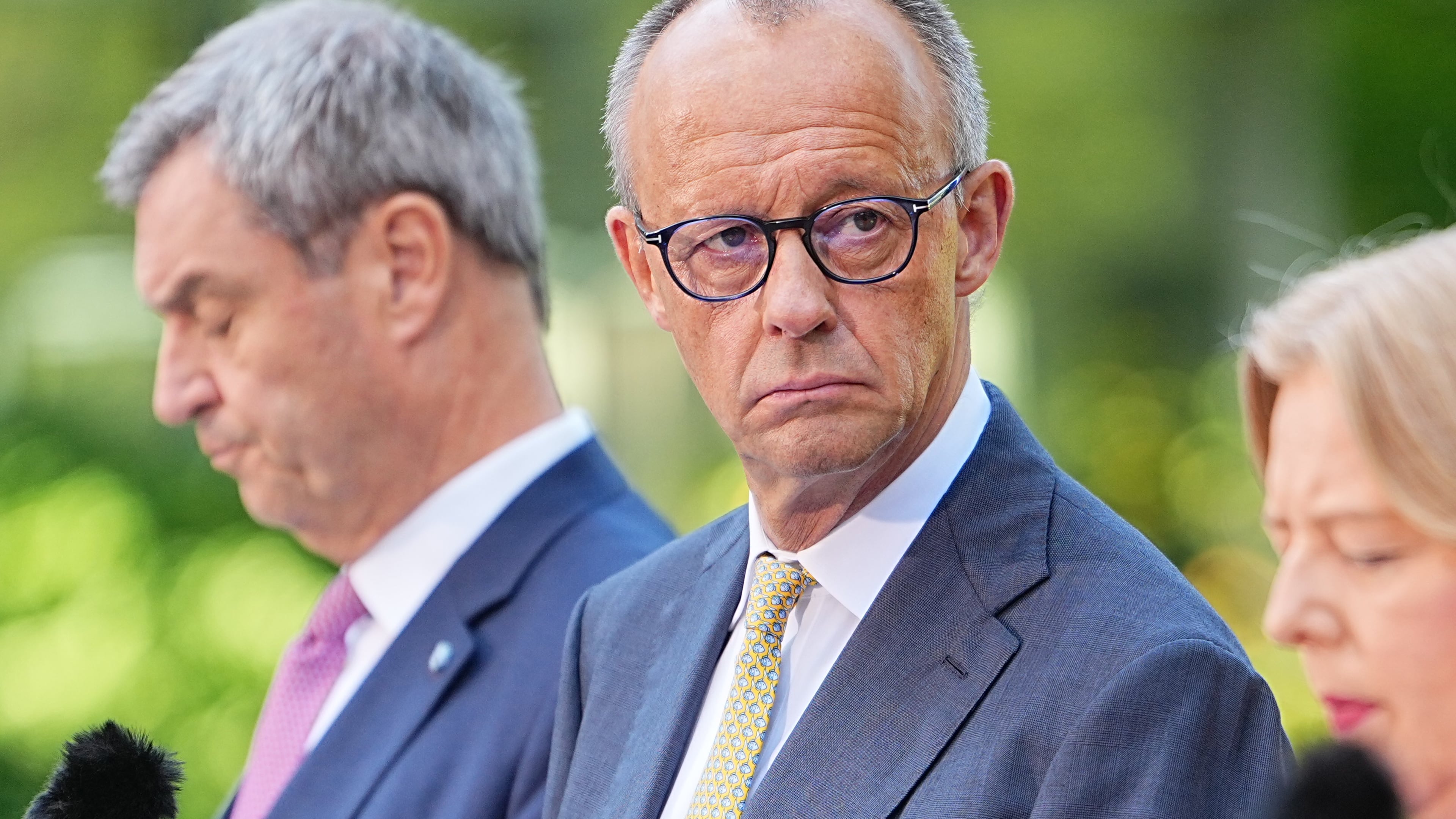 German Federal Chancellor Friedrich Merz, center, attends a press conference with Minister-President of Bavaria and CSU Chairman Markus Söder, left, Federal Minister of Labor and Social Affairs Bärbel Bas, right and Federal Minister of Finance, Lars Klingbeil, in the garden of the Chancellery following the meeting of the coalition committee, in Berlin, Thursday, July 2, 2026. (Michael Kappeler/dpa via AP)
