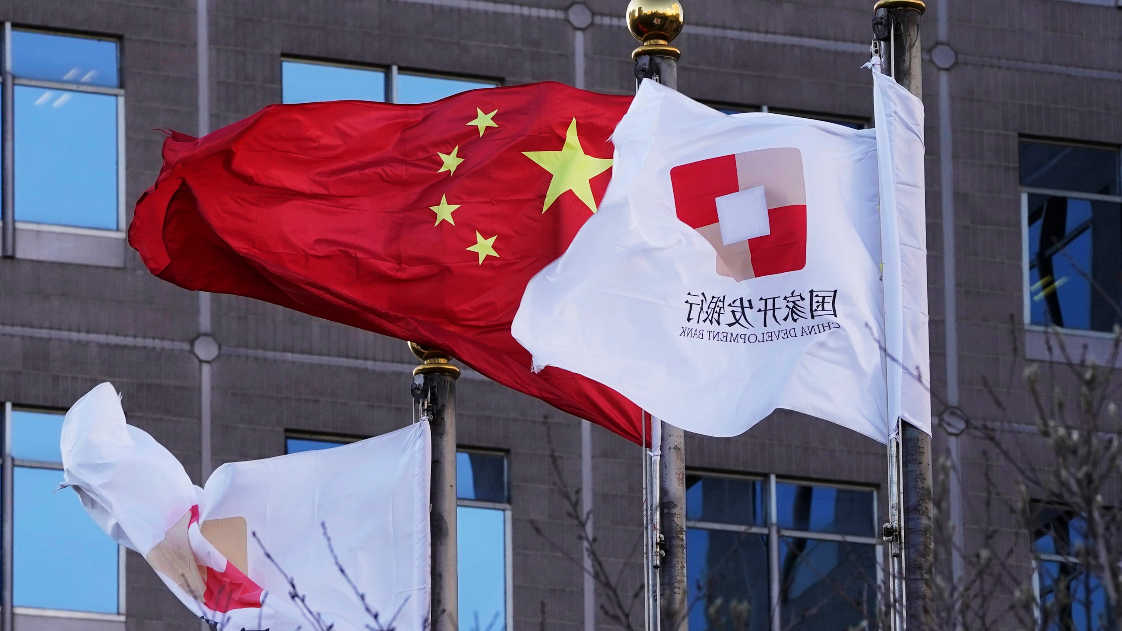 FILE - Flags of the China Development Bank are flown near a Chinese flag outside a subsidiary branch office of the Bank in Beijing, Jan. 8, 2021. (AP Photo/Ng Han Guan, File)
