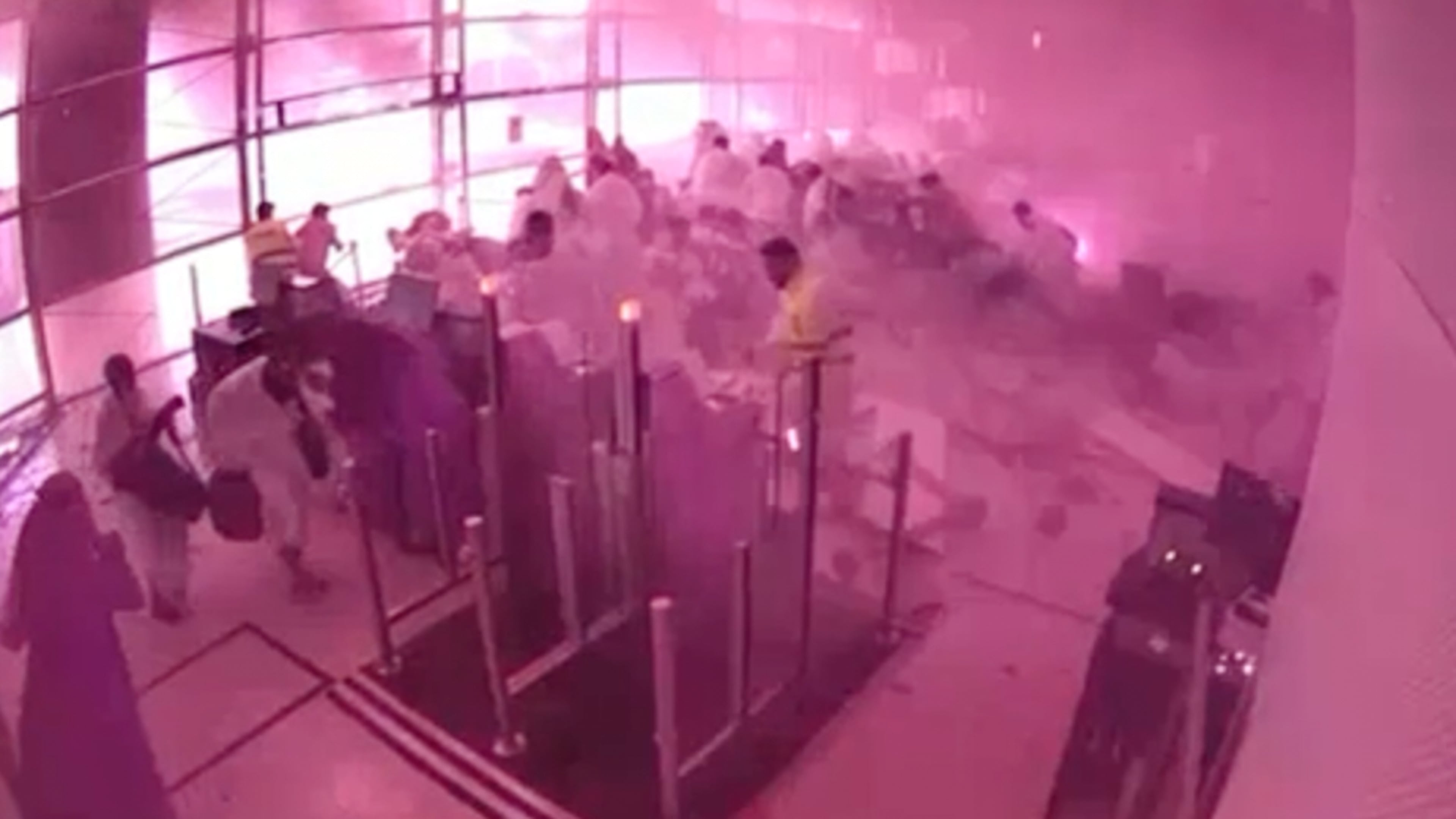 This image from CCTV video released by Saudi Arabia's Media Ministry shows passengers taking cover as flames and smoke fill part of King Khalid International Airport in Riyadh, Saudi Arabia, during what authorities described as a strike at the airport on Saturday, Oct. 10, 2026. (Saudi Media Ministry via AP)