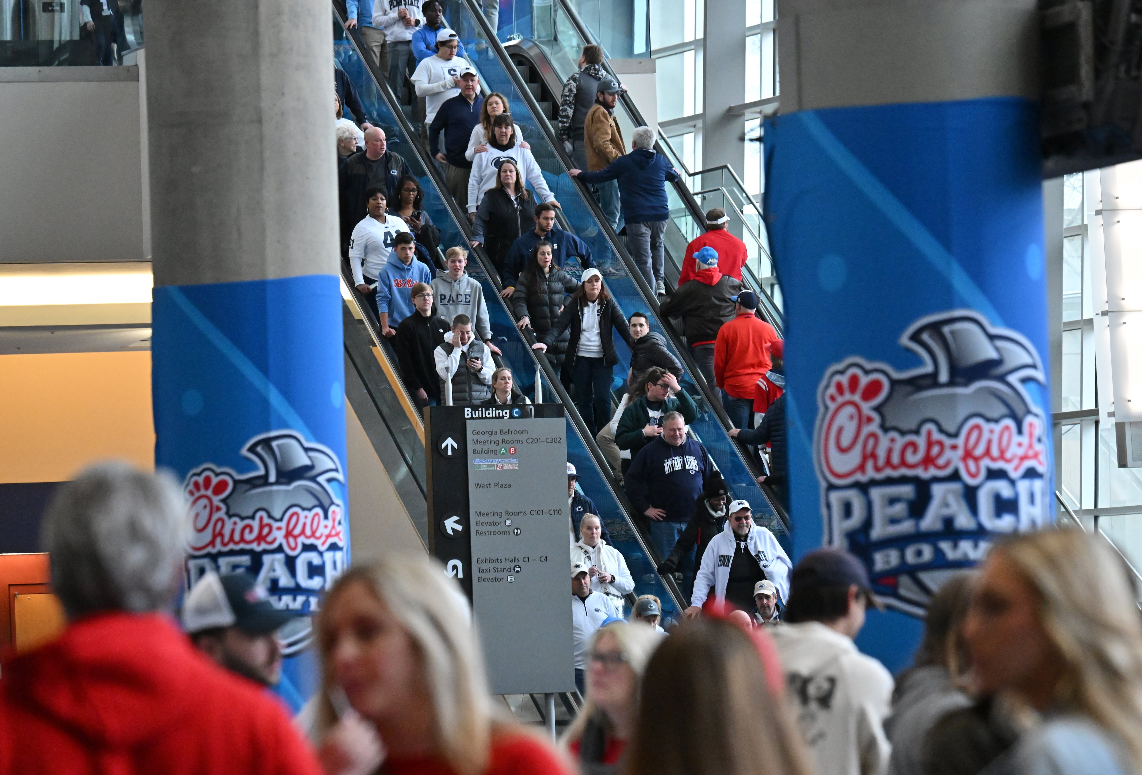Football fans head to FanFest at Georgia World Congress Center prior to 2023 Chick-fil-A Peach Bowl between Ole Miss and Penn State, Saturday, December 30, 2023, in Atlanta. (Hyosub Shin / Hyosub.Shin@ajc.com)