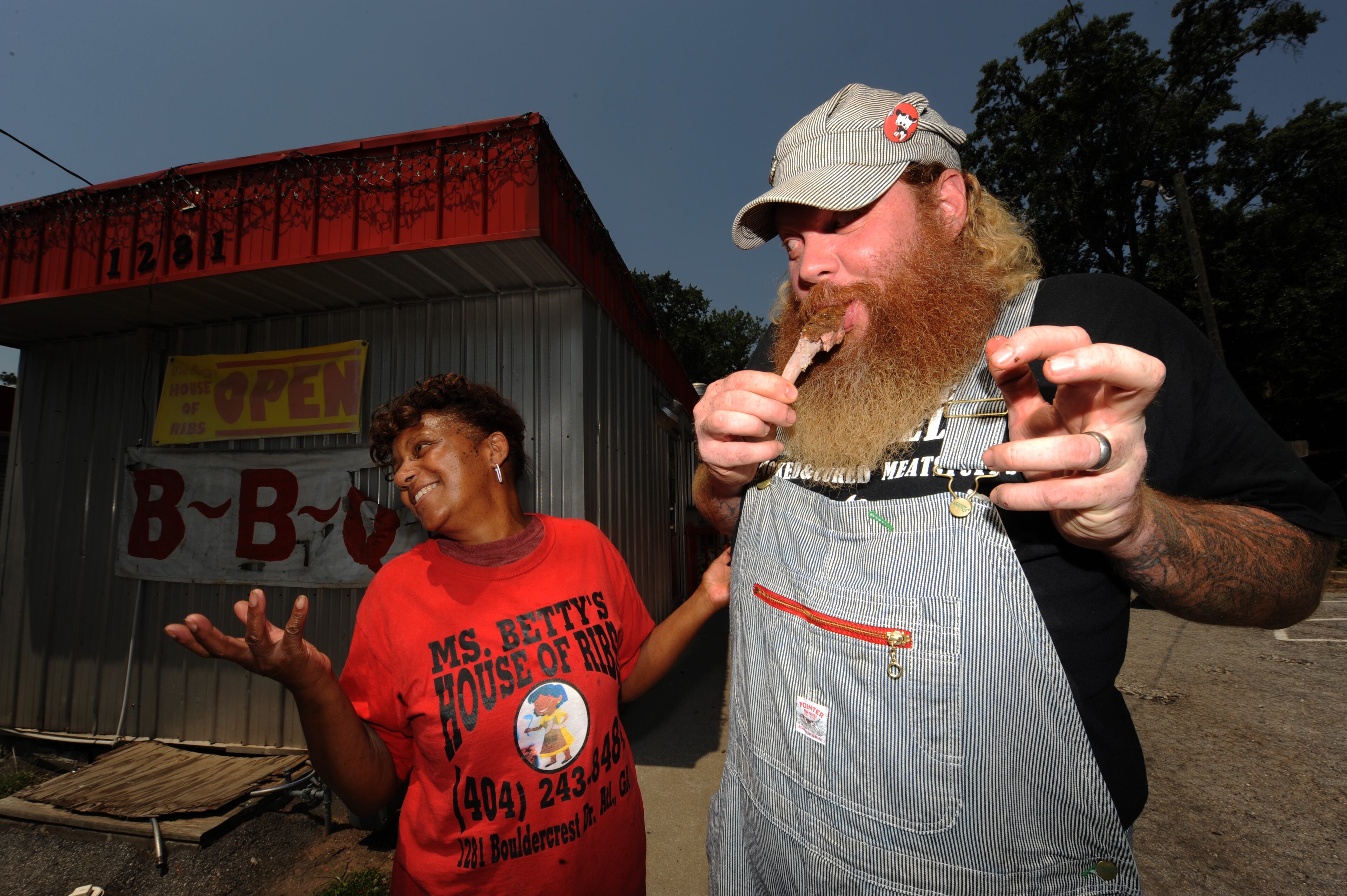 Betty Hamilton and Jim Stacy laugh and talk as Stacy eats a rib in front of Ms. Betty's House of Ribs on Friday, June 29, 2012. One of Public Broadcasting most popular locally produced programs is "Get Delicious, " a journey of local food establishments led by Stacy. JOHNNY CRAWFORD / JCRAWFORD@AJC.COM