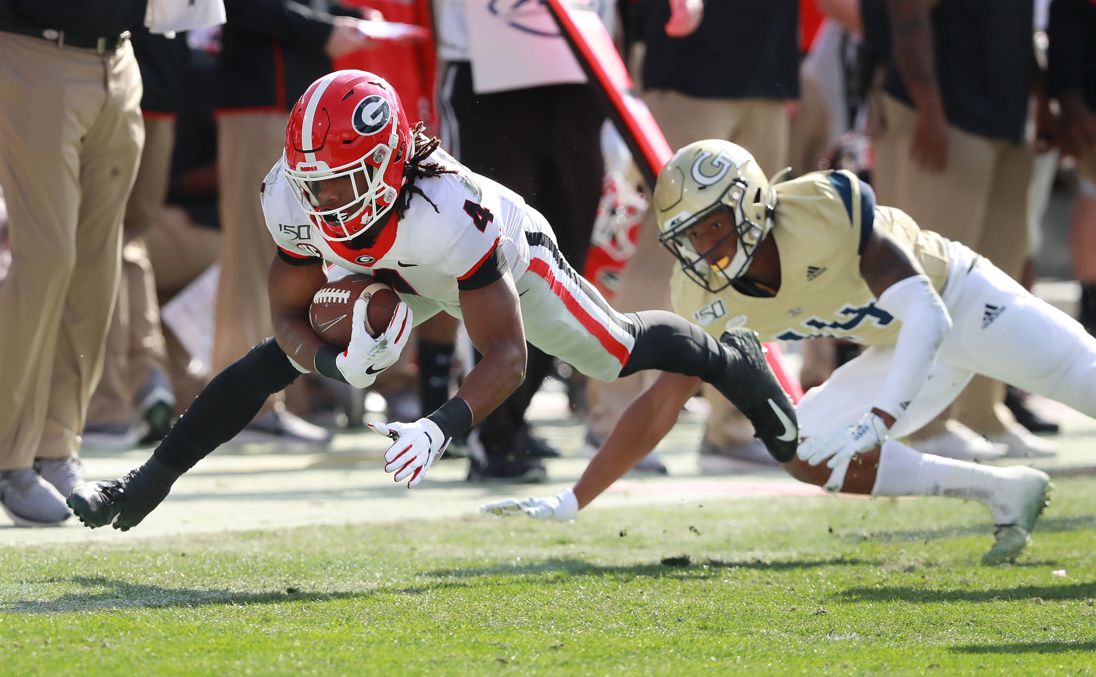 Georgia tailback James Cook stretches for extra yardage past Georgia Tech defender Jaylon King during the first half in a NCAA college football game on Saturday, November 30, 2019, in Atlanta. Curtis Compton/ccompton@ajc.com