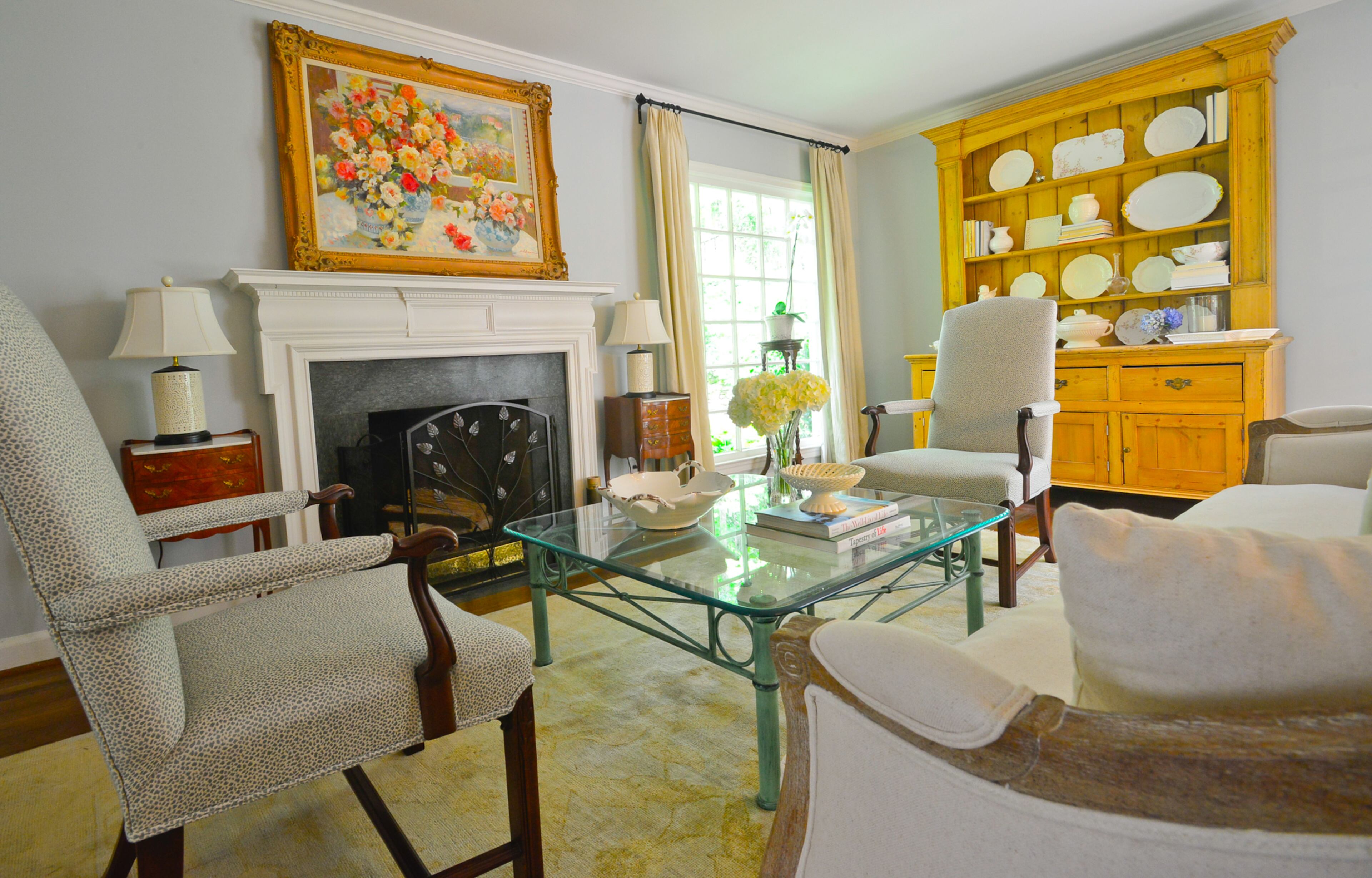 The living room reflects how the Buckhead homeowners have combined their design styles. TJ Callaway enjoys attending auctions for traditional pieces, such as wingback chairs that were recovered, for his home and Onward Reserve stores. Wife Catherine brings in contemporary components such as the glasstop table to add contrast and make the home feel fresh.
