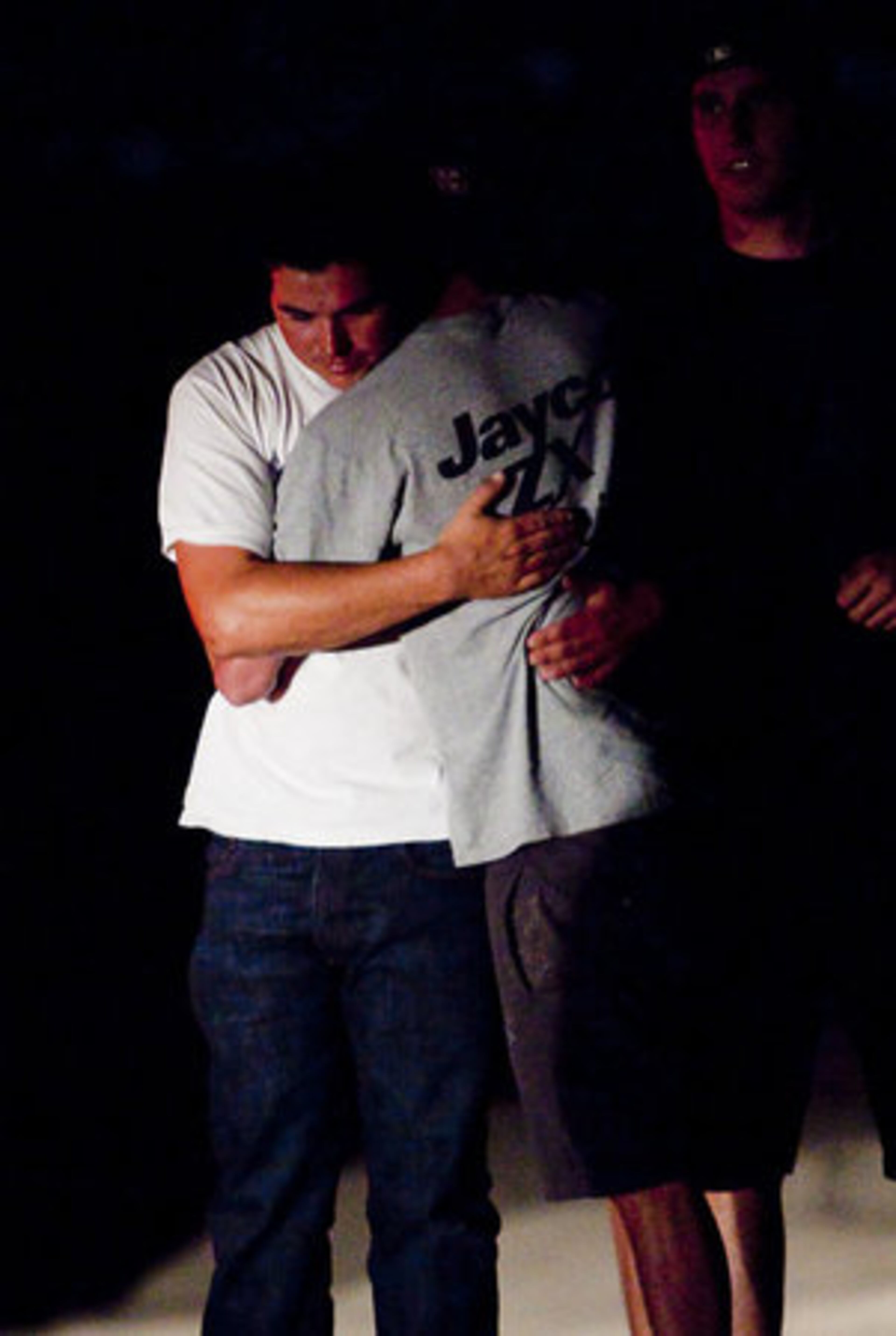 Two people hug at the accident scene early Sunday morning. The driver "hit the rock and just lost control and tumbled," said one witness, who was standing next to the jump. "Bodies went everywhere."