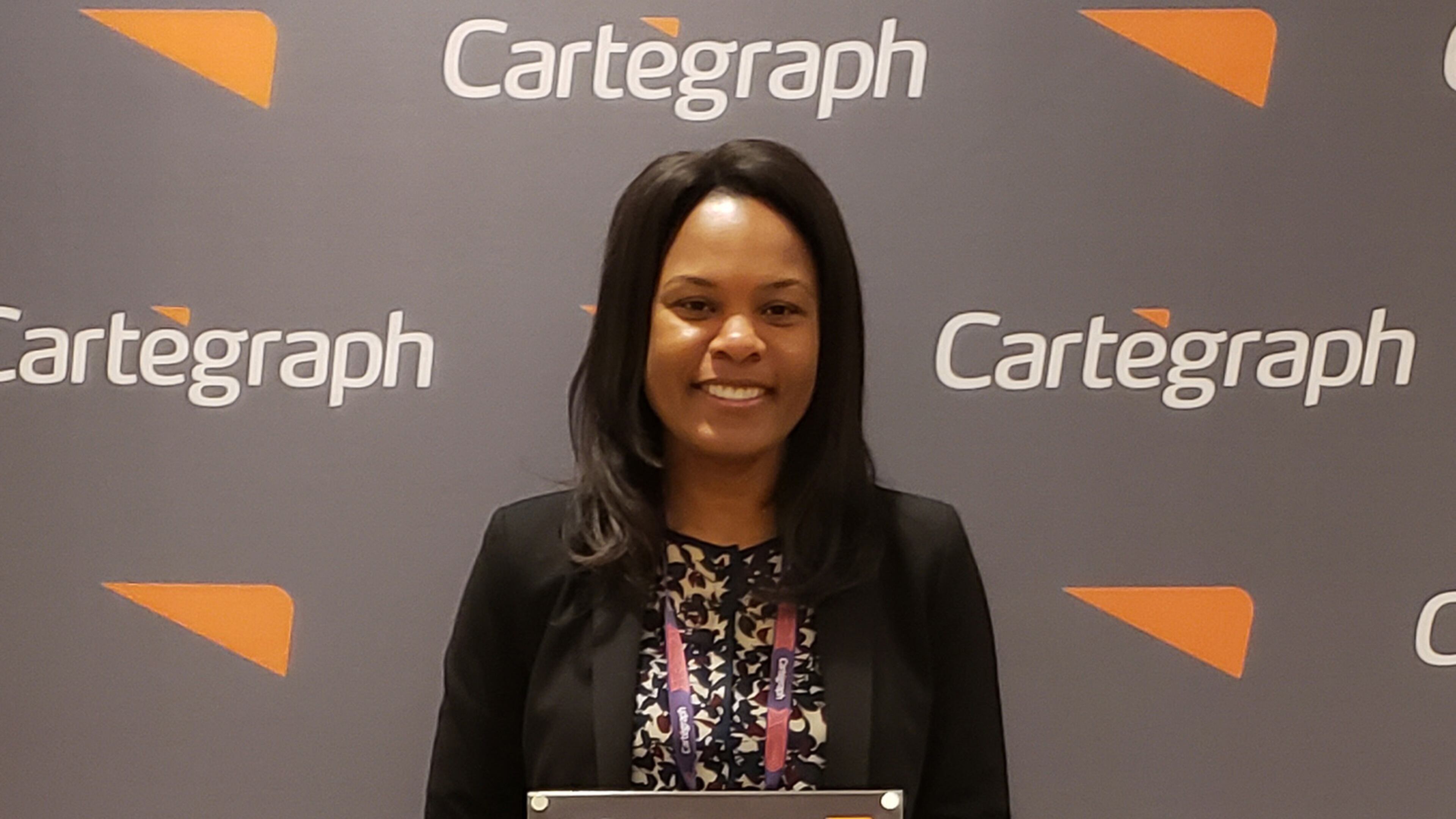 Nadine Bennett-Darby, CCDOT geographic information system (GIS) solutions analyst, shows the award she accepted on behalf of the Cobb County Department of Transportation at the Cartegraph Conference as one of the top 10 U.S. governmental entities. (Courtesy of Cobb County)