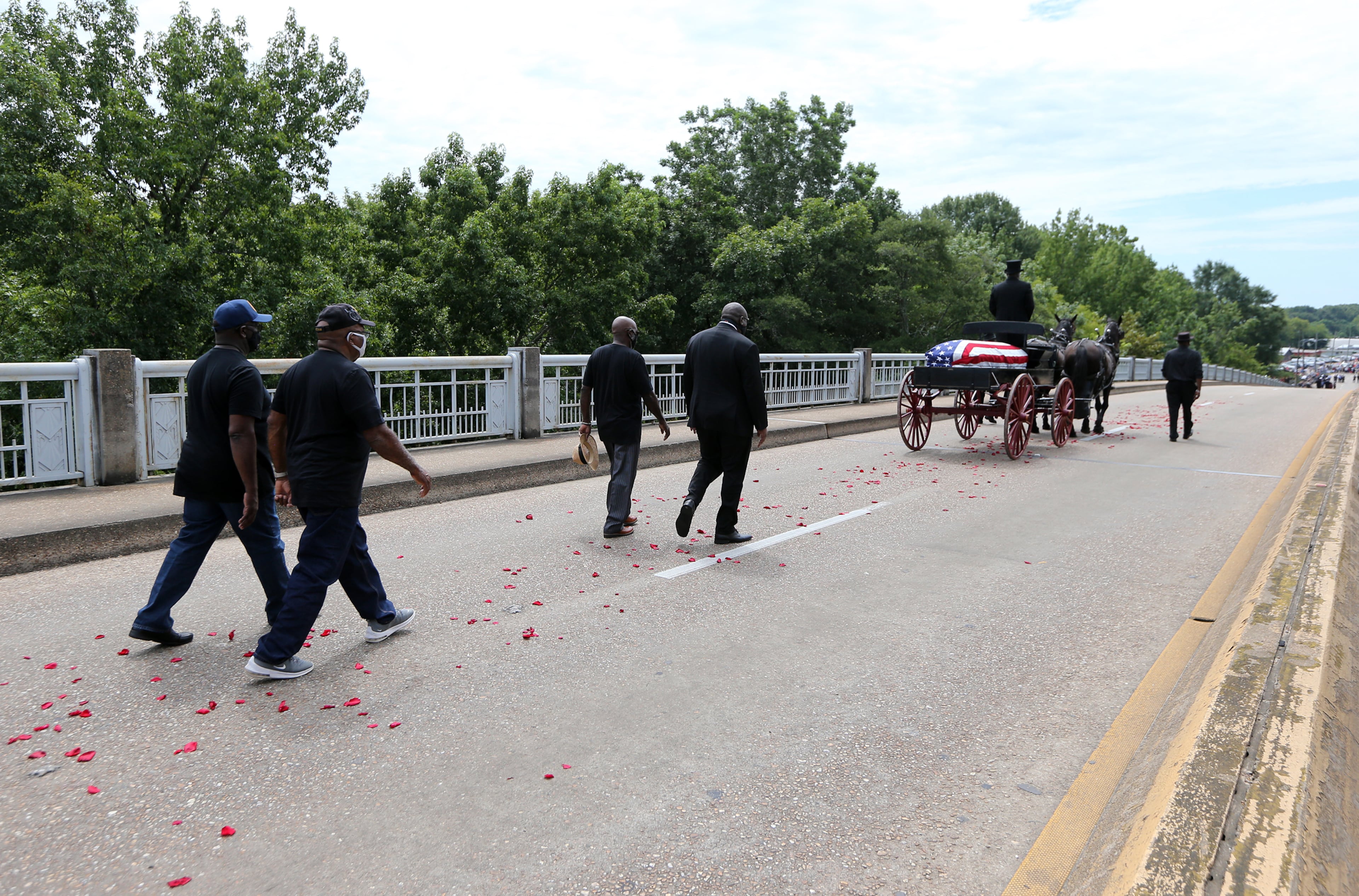 072620 Selma: The body of Rep. John Lewis makes the final crossing over the Edmund Pettus Bridge, site of the historic 1965 voting rights marches, with family members walking behind on Sunday, July 26, 2020 in Selma. The congressman from Georgia and civil rights icon died July 17 at age 80 after a battle with pancreatic cancer. Curtis Compton ccompton@ajc.com