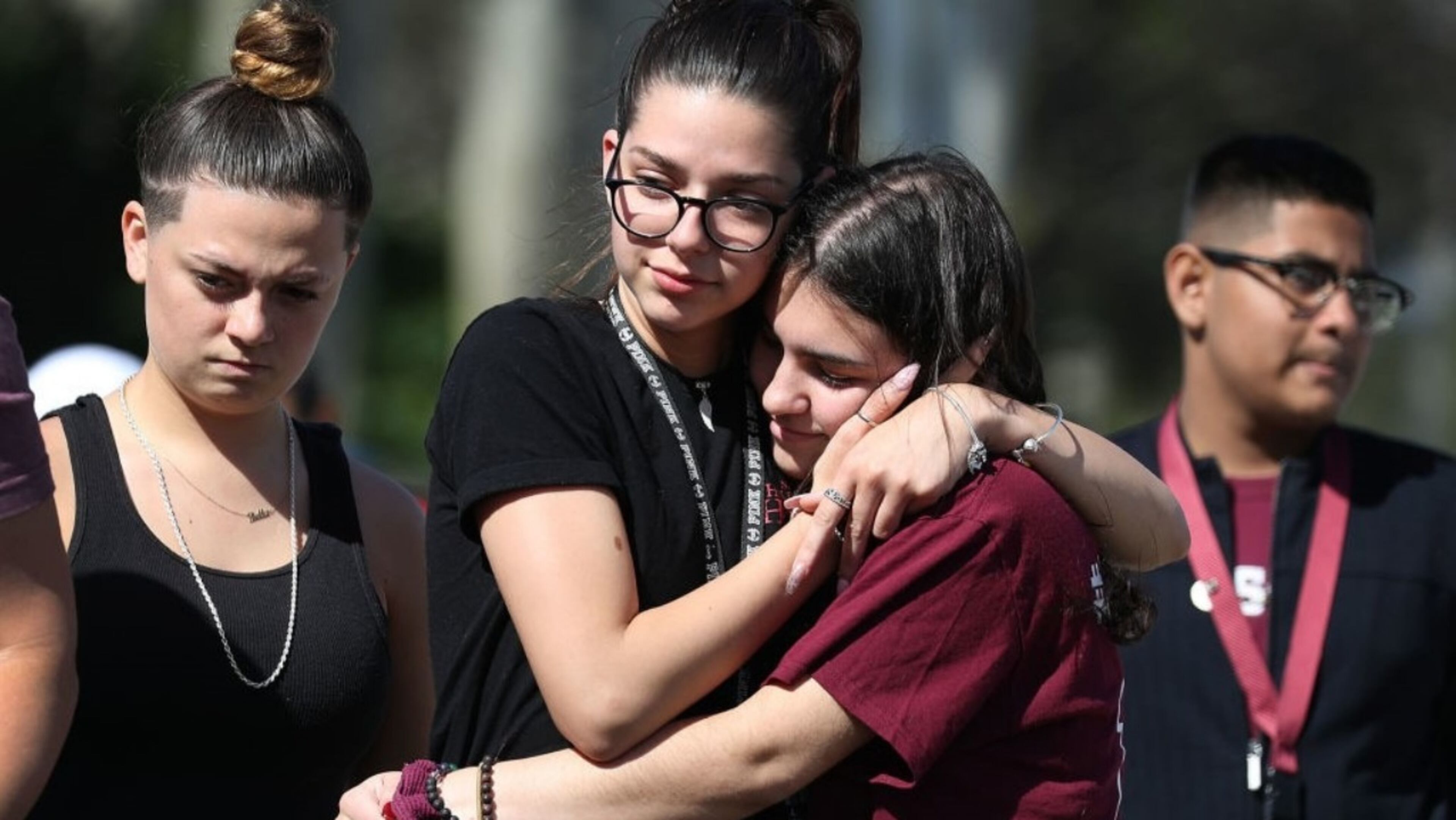 PARKLAND, FLORIDA -- Bella Montecino, who left Marjory Stoneman Douglas High School after the shooting, and Makenzie Henser (L-R), who is a junior at Marjory Stoneman Douglas High School, comfort each other as they remember those lost during a mass shooting at the school on February 14, 2019 in Parkland, Florida. A year ago on Feb. 14th at Marjory Stoneman Douglas High School 14 students and three staff members were killed during the mass shooting.
