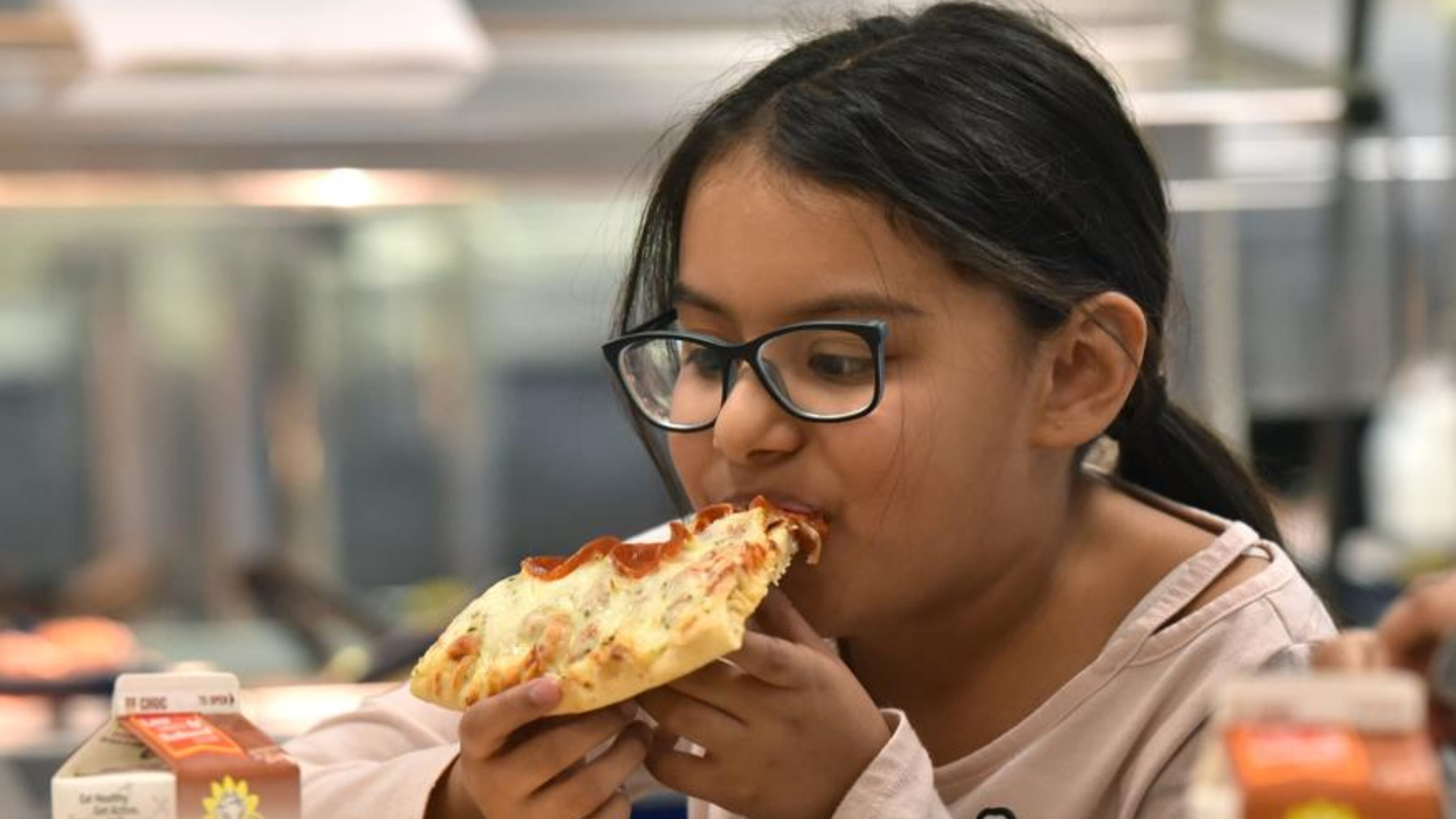 Student Angelic Ventura, 8, eats a slice of pizza with whole wheat crust for her lunch at Corley Elementary School on Wednesday, Dec. 12, 2018. Agriculture Secretary Sonny Perdue recently announced new school-meal guidelines designed to increase local flexibility in implementing nutrition standards for milk, whole grains and sodium.