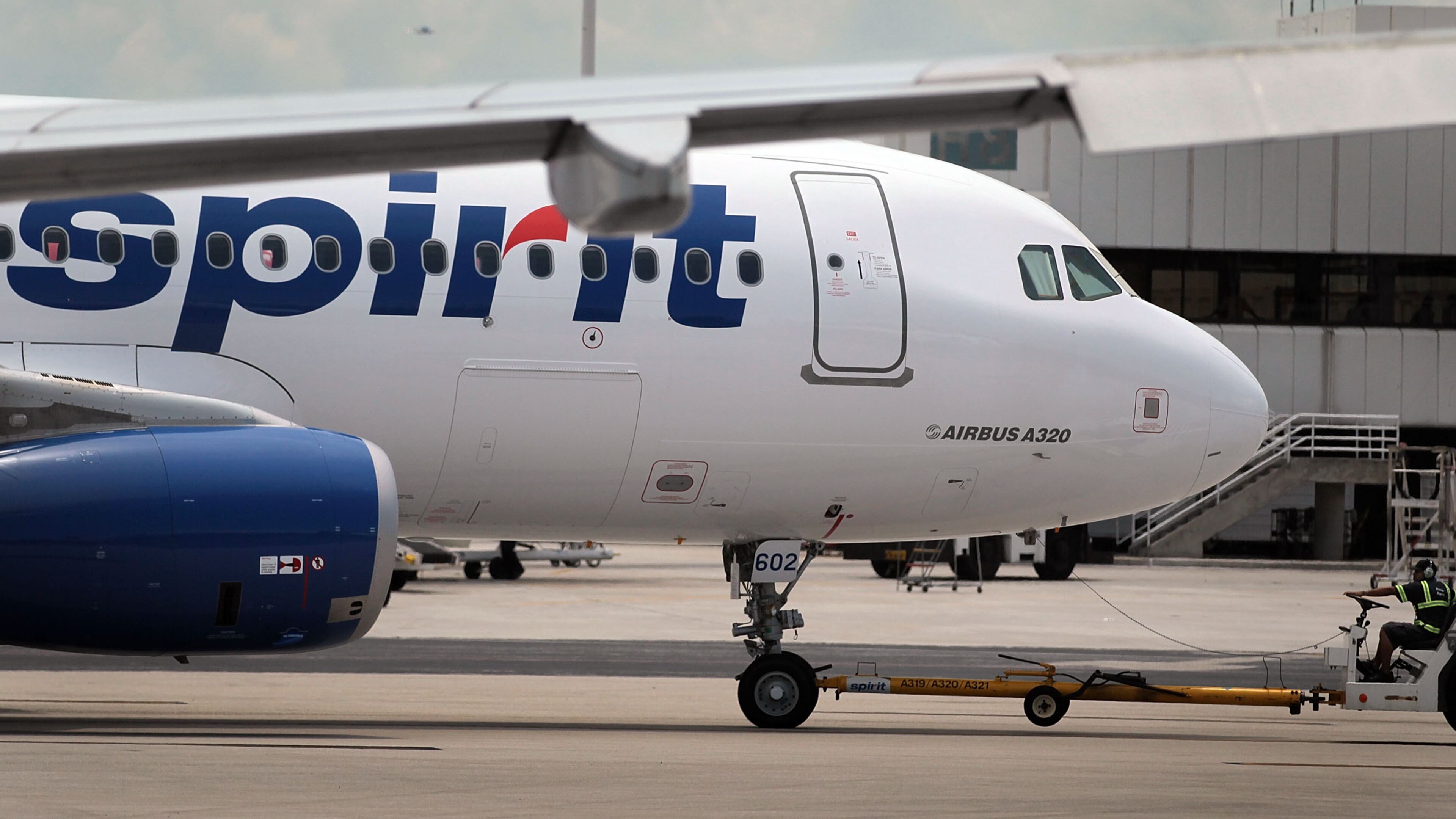 A Spirit Airlines Inc. employee uses a machine to tow a plane on the tarmac at the Fort Lauderdale International Airport in 2010 in Fort Lauderdale, Florida. (Photo by Joe Raedle/Getty Images)