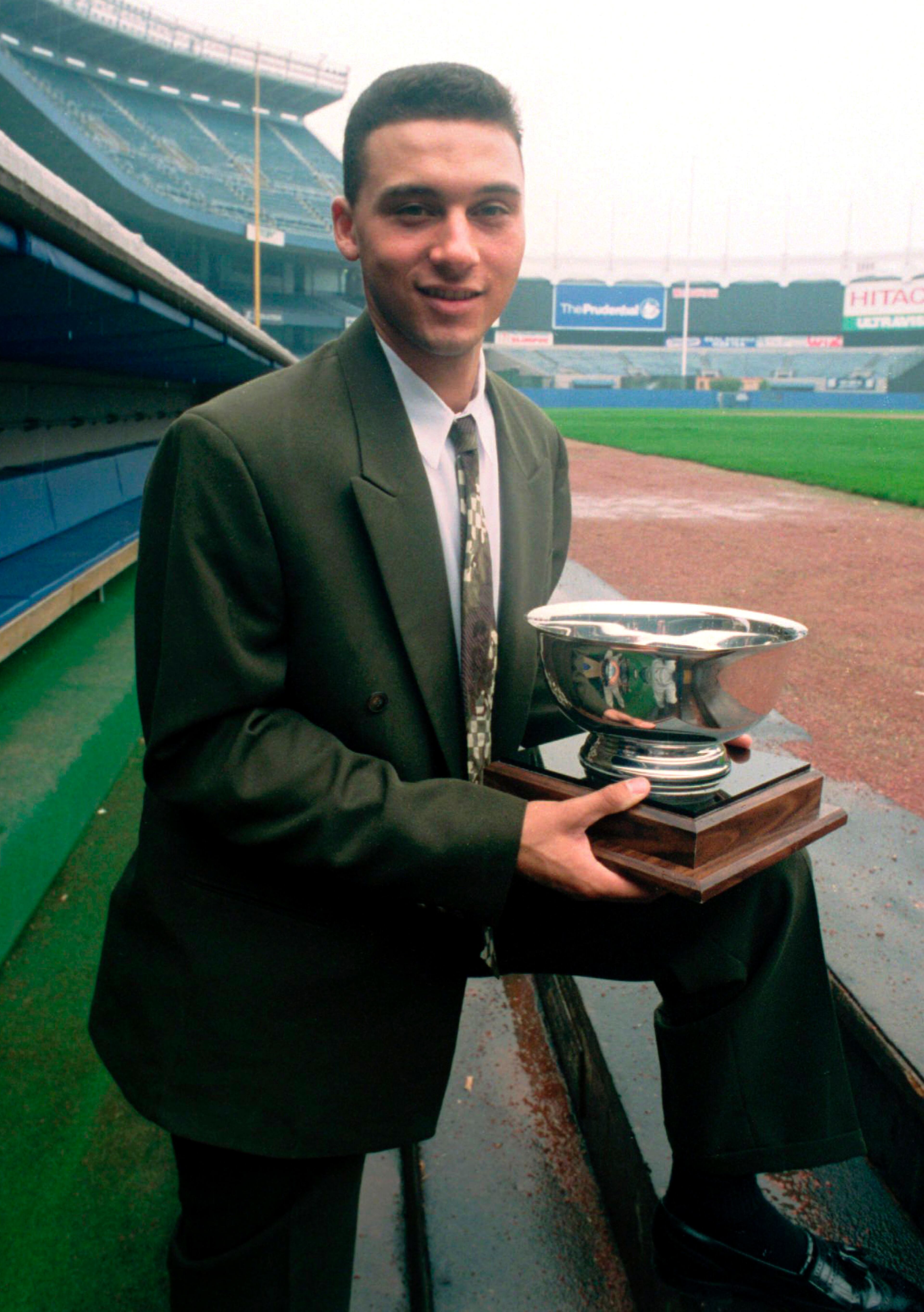 FILE - In this Sept. 14, 1994 file photo, New York Yankees shortstop prospect Derek Jeter poses on the dugout steps at Yankee Stadium in New York after he was named Baseball America's minor league player of the year. The 20-year-old from Kalamazoo, Mich., finished the season at Triple-A in Columbus, Ohio. A five-time World Series champion and sixth on the career hits list, Jeter, now 40, is set to retire after this season after spending two decades as the shortstop for the Yankees. (AP Photo/Mark Lennihan, File)