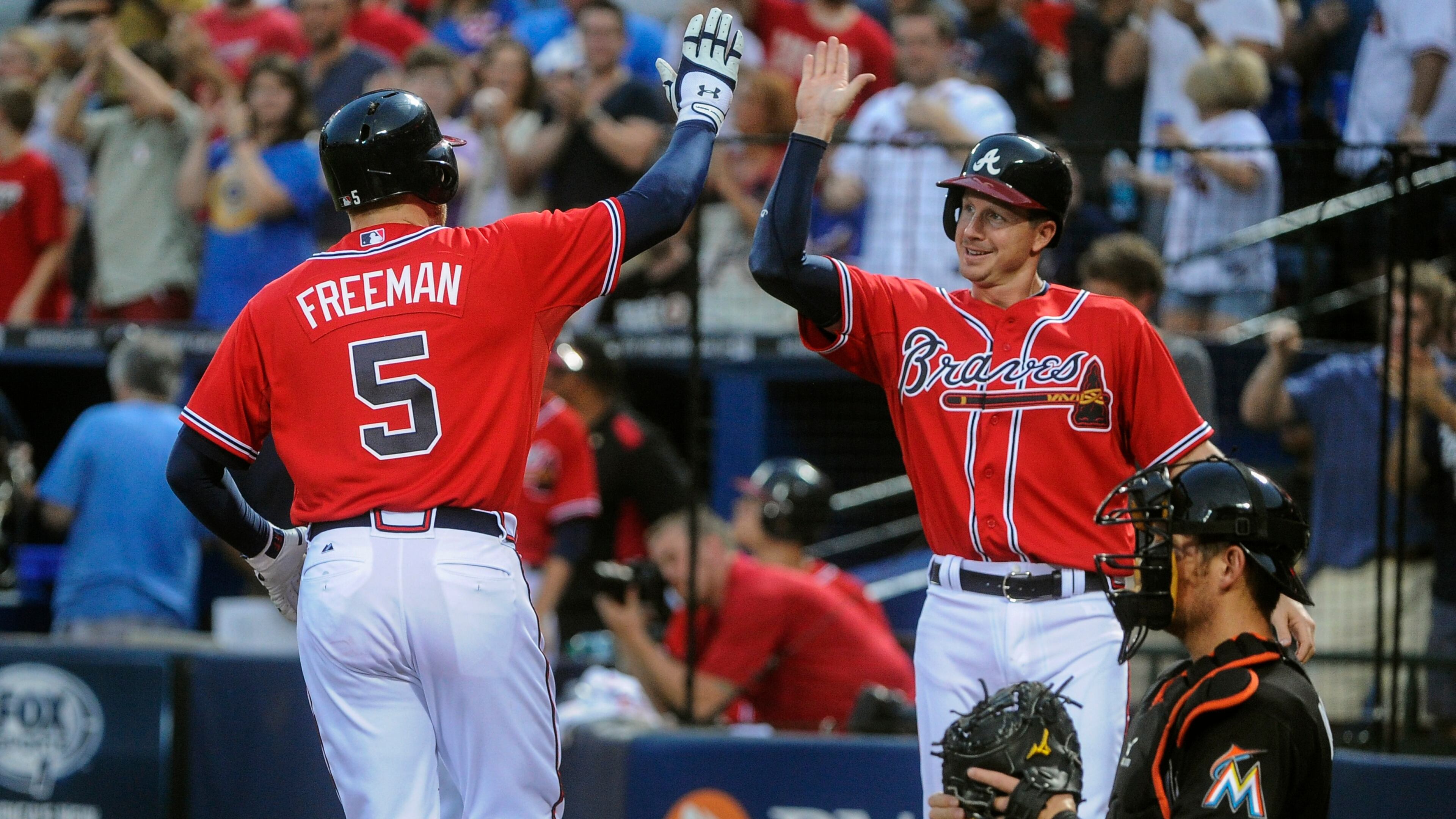 Atlanta Braves' Freddie Freeman (5) is welcomed to home plate by Elliot Johnson on Freeman's home run against the Miami Marlins during the first inning of a baseball game, Friday, Aug. 30, 2013, in Atlanta. Atlanta won 2-1. (AP Photo/John Amis)