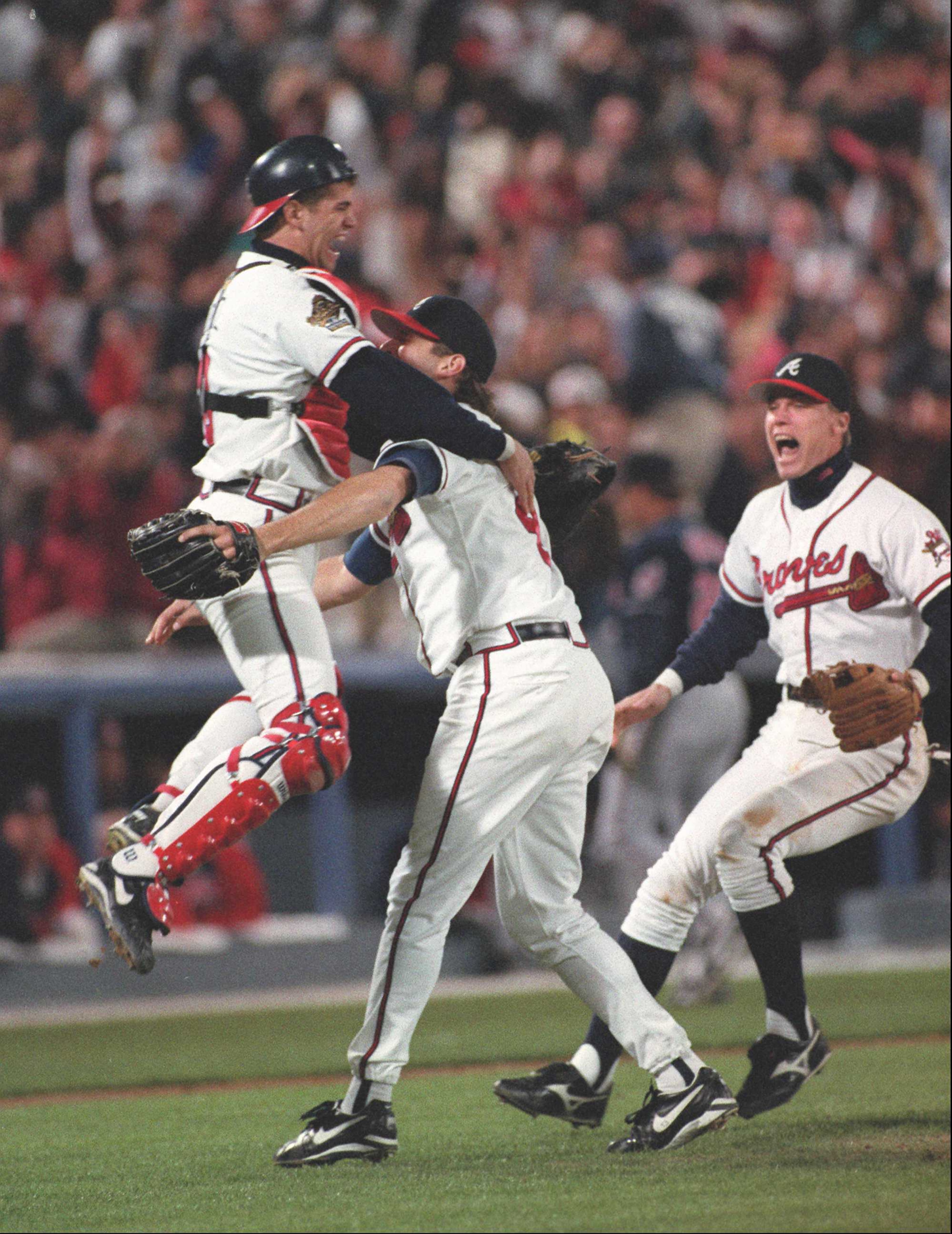 Javier Lopez leaps into the arms of Mark Wohlers after the last out of the 1995 World Series, Saturday, October 28, 1995. Chipper Jones is at the right.