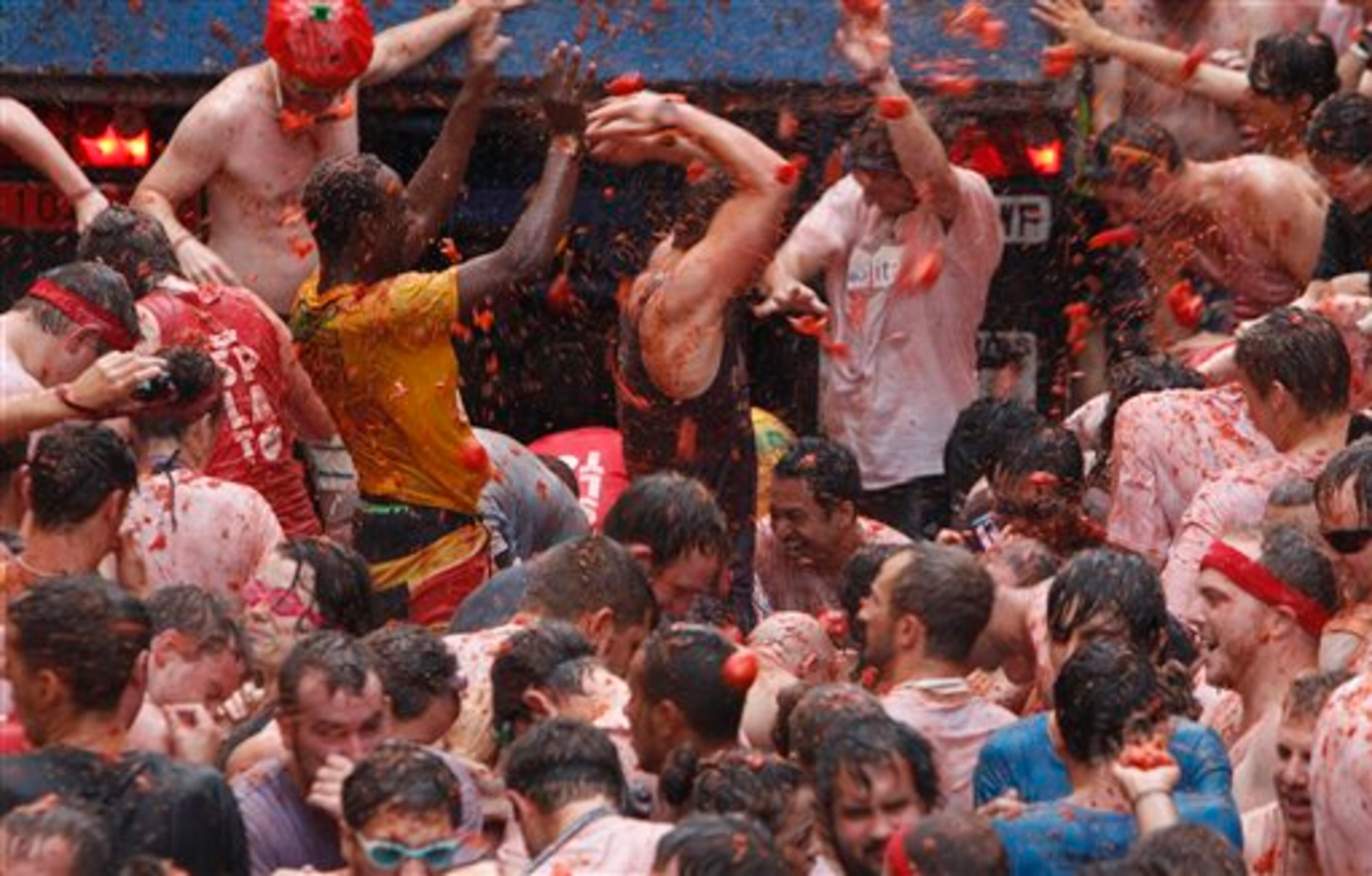Crowds of people throw tomatoes at each other during the annual "tomatina" tomato fight fiesta in the village of Bunol, 50 kilometers outside Valencia, Spain, Wednesday, Aug. 28, 2013. (AP Photo/Alberto Saiz)