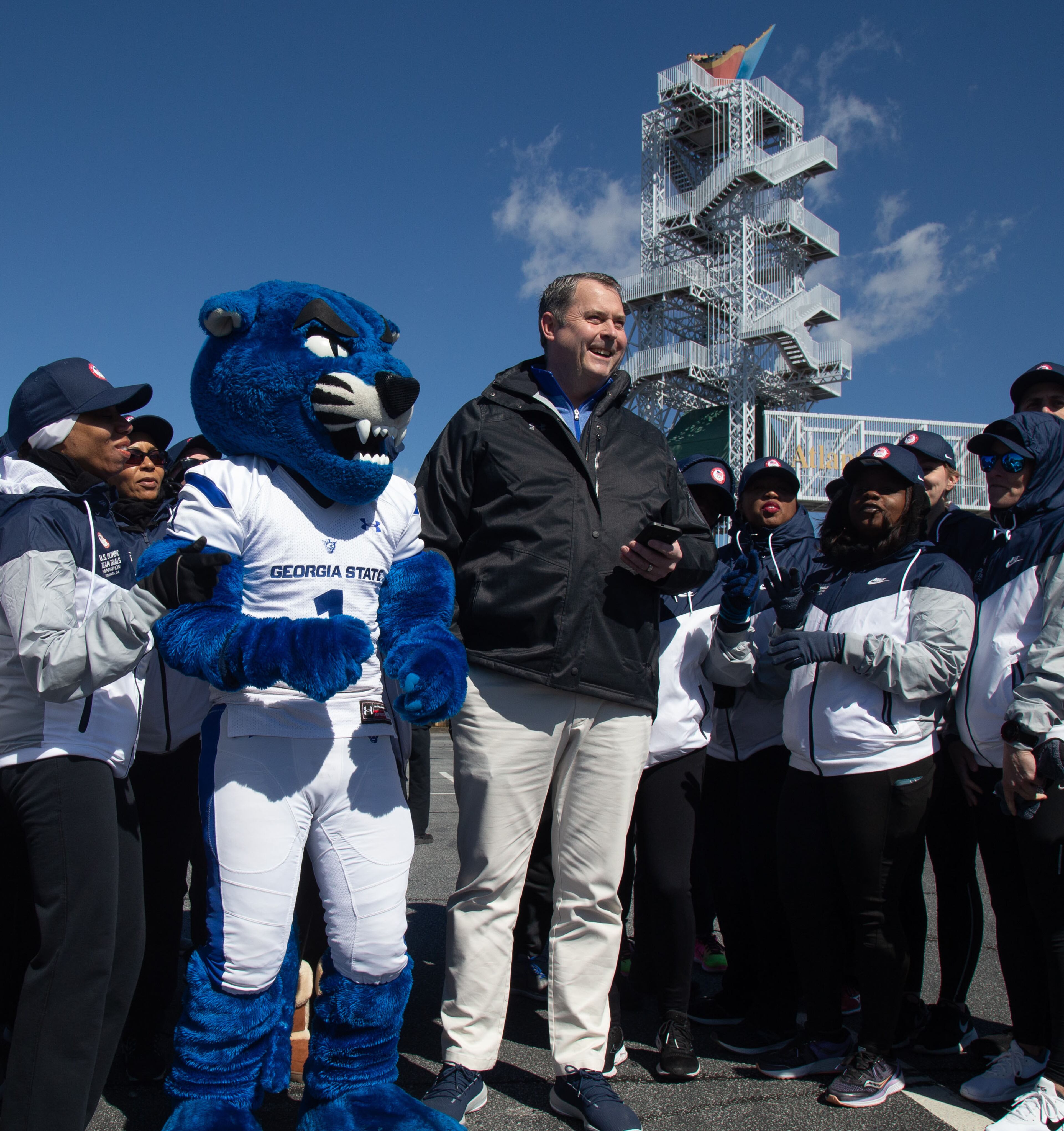 Georgia State University Athletics Director Charlie Cobb (C) uses an app to light the Olympic cauldron for the U.S. Olympic Team marathon trials in Atlanta on Saturday, February 29, 2020. STEVE SCHAEFER / SPECIAL TO THE AJC