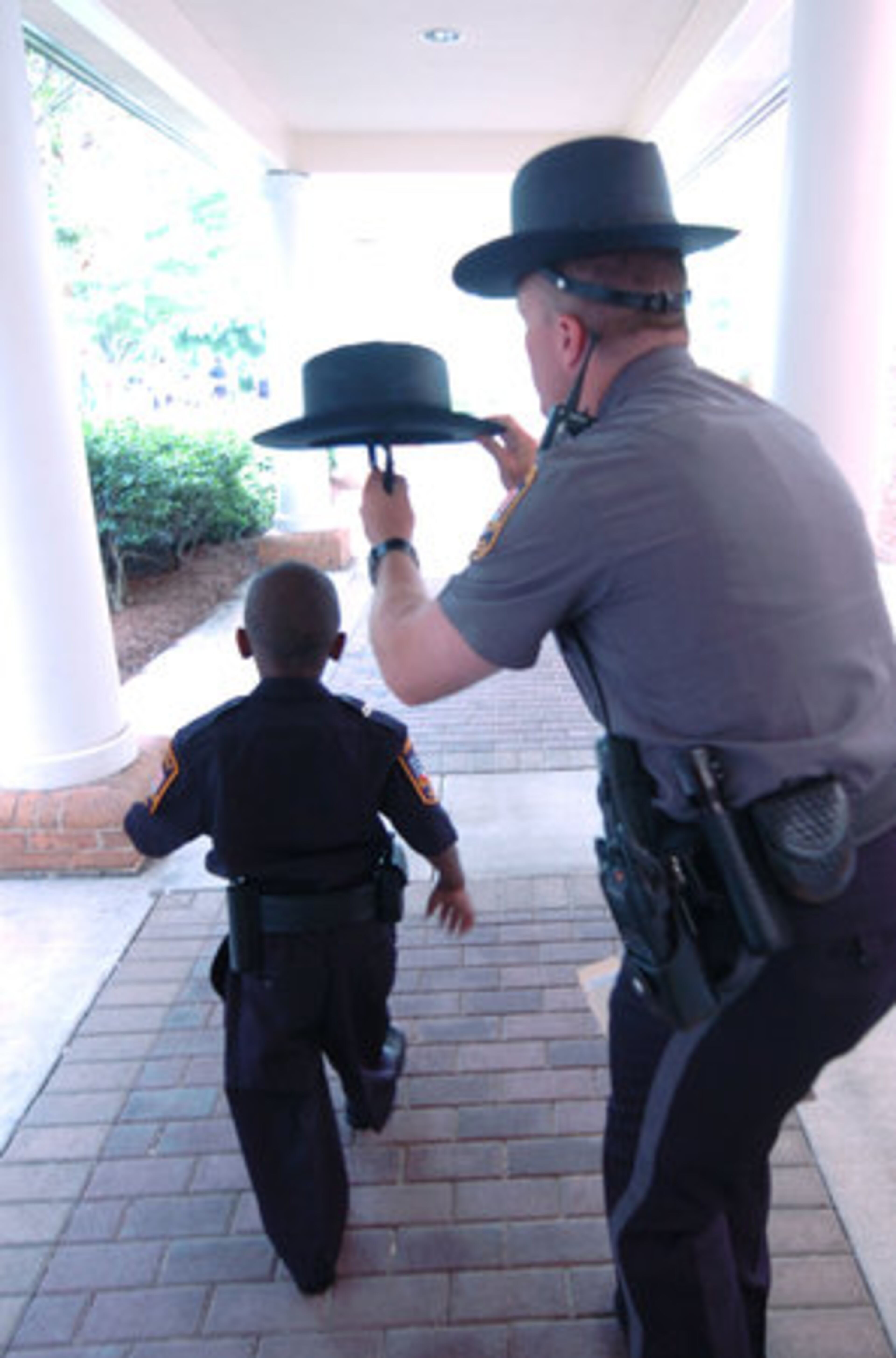 Darrien gets some help with his hat from Hegwood. Darrien was heading outdoors and officers are expected to wear the headgear outside. Darrien had obviously forgotten, but Hegwood backed him up.