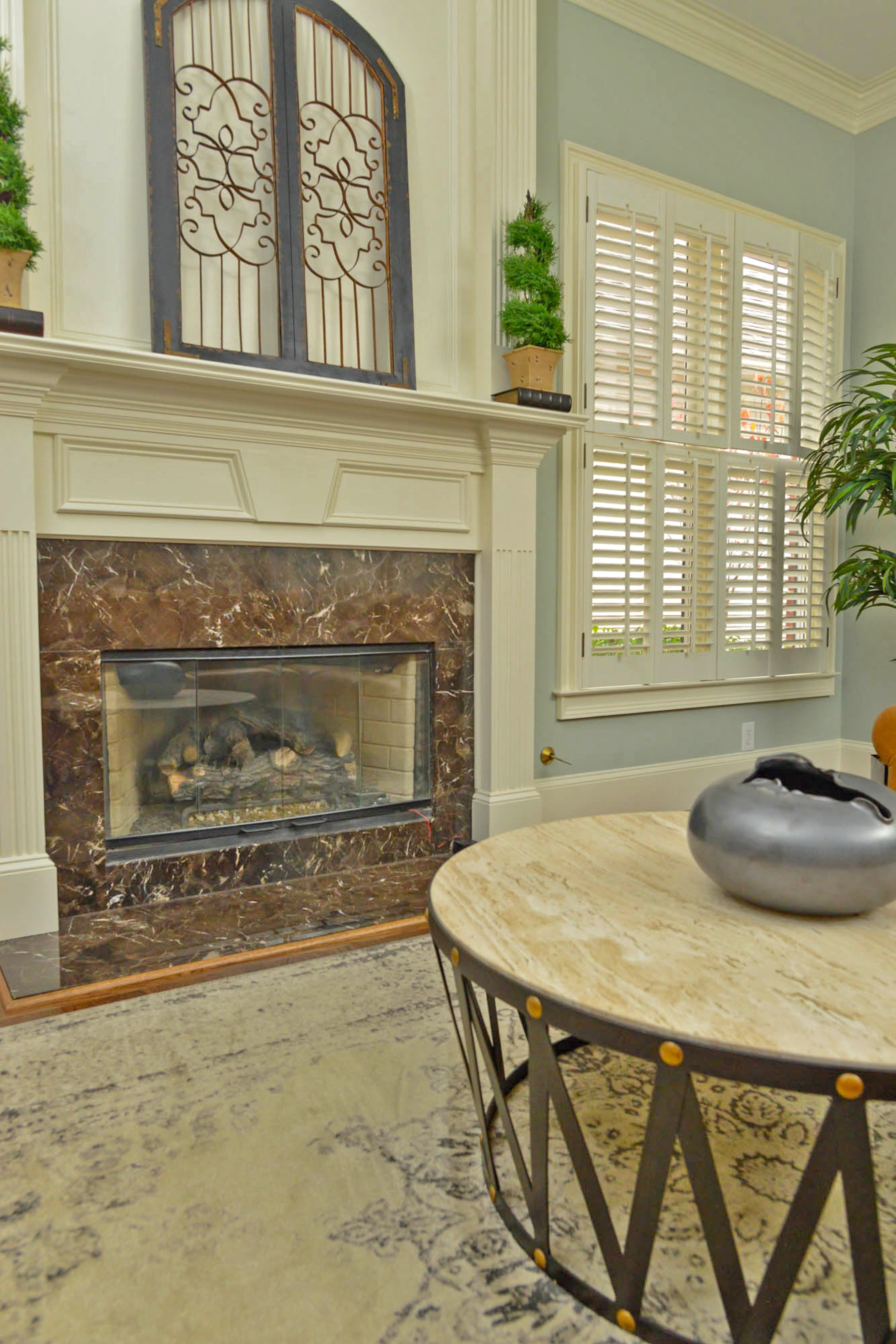 The Travertine Drum Round Cocktail Table from Bassett has a hand-forged iron base and travertine stone top. The table's design is inspired by military drums.