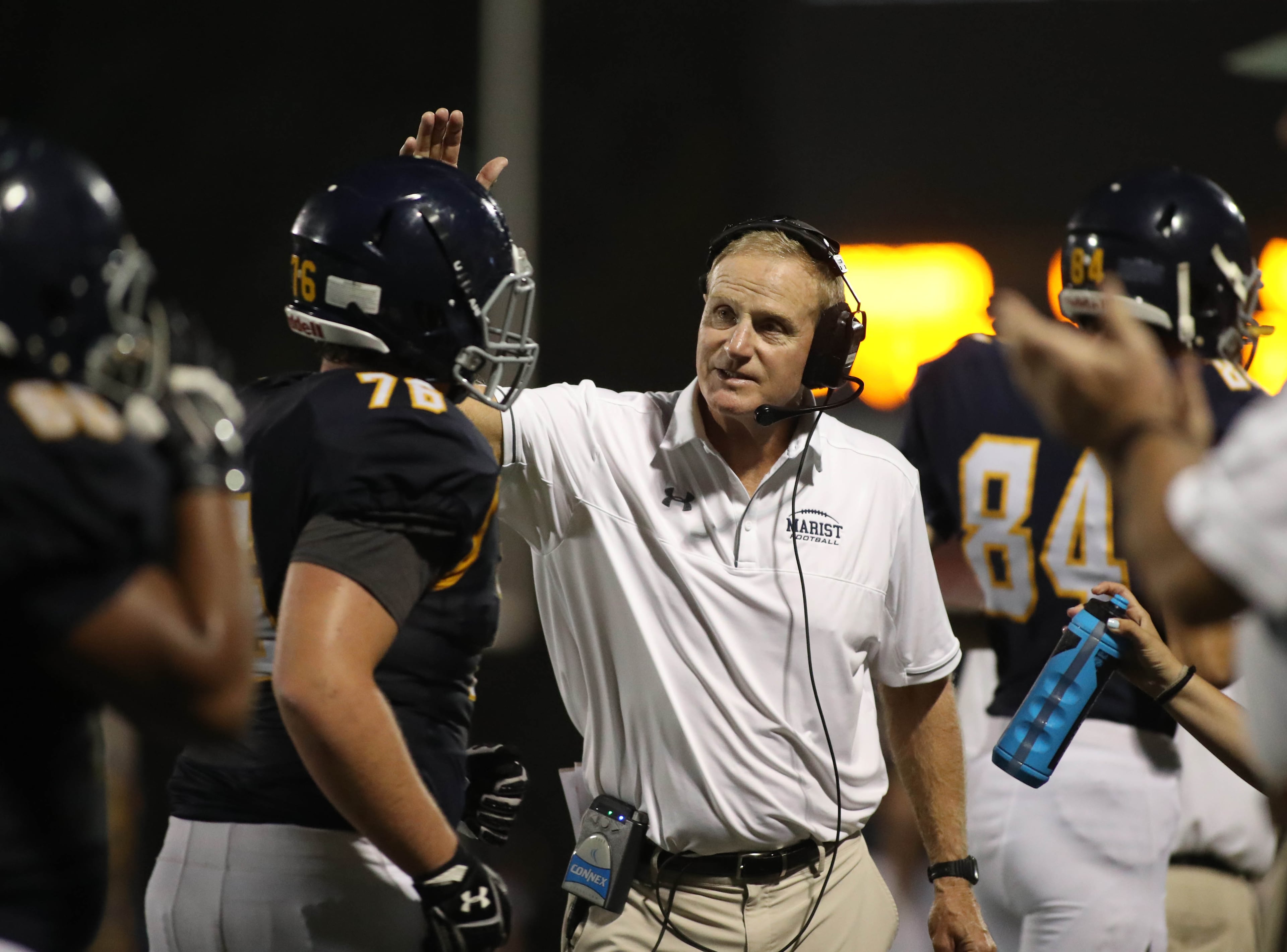 Marist head coach Alan Chadwick celebrates a touchdown with offensive lineman Mark Shepherd (76) in the second half against Woodward Academy at Marist Friday, September 15, 2017, in Atlanta. Marist won 34-17. PHOTO / JASON GETZ