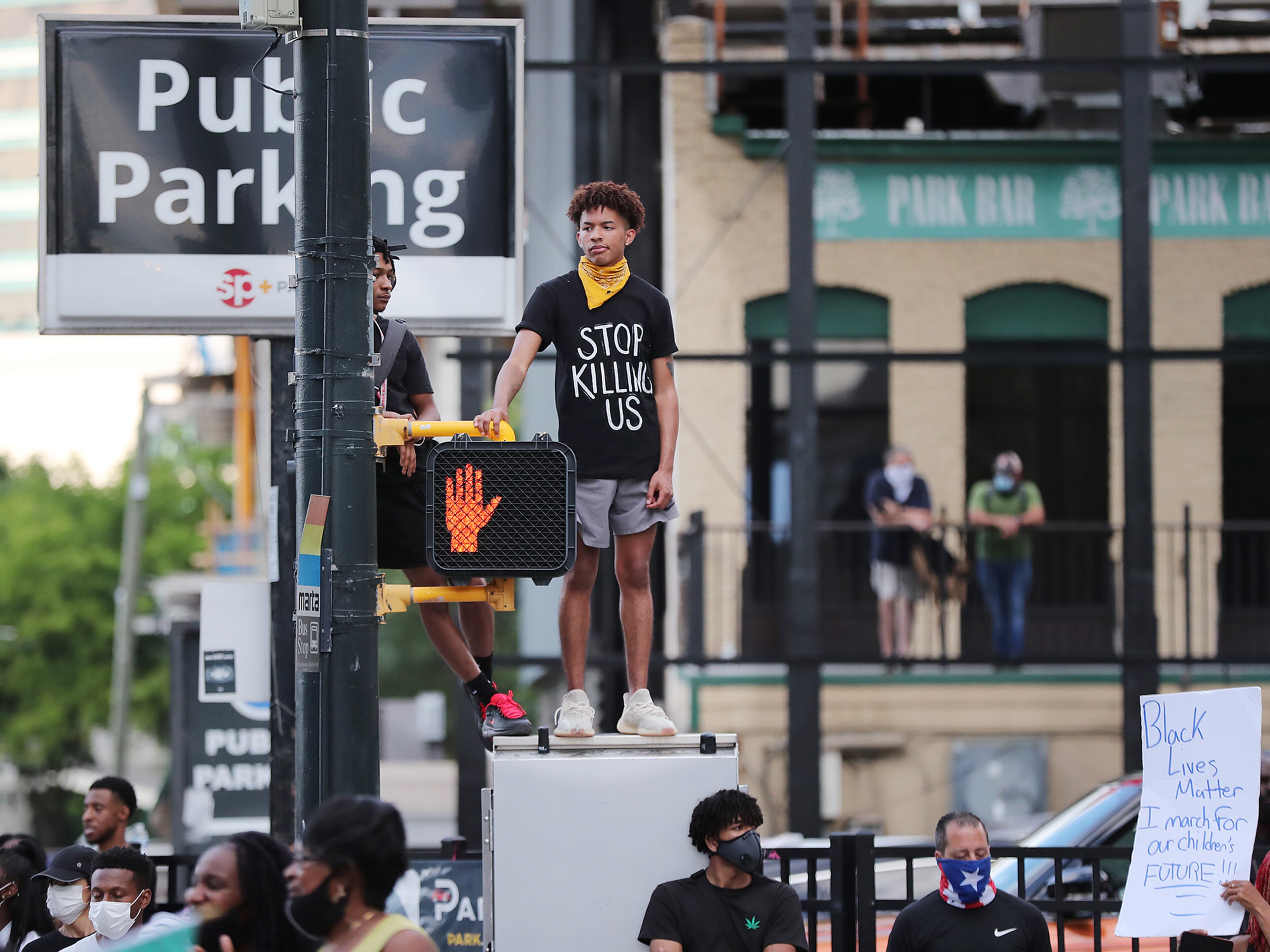 053120 Atlanta: A protester stands on top of a crossing box on Marietta Street outside the CNN Center at Olympic Park during the third day of protests over the death of George Floyd on Sunday, May 31, 2020, in Atlanta. Curtis Compton ccompton@ajc.com