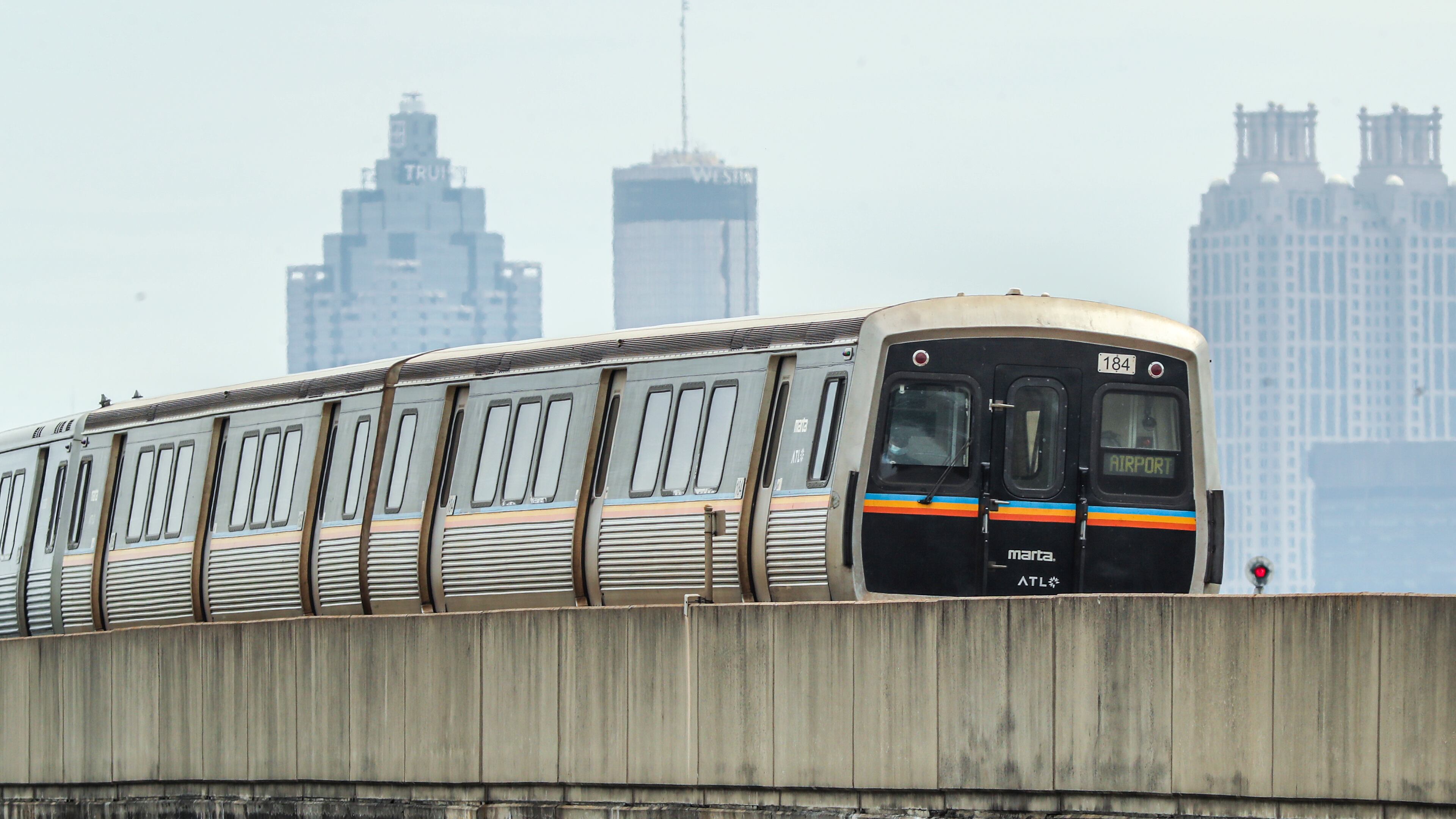 June 3, 2022 Atlanta: A MARTA train makes its way down the South track near Arlington Avenue on Friday, June 3, 2022, as the Atlanta skyline is shrouded in haze. (John Spink / John.Spink@ajc.com)