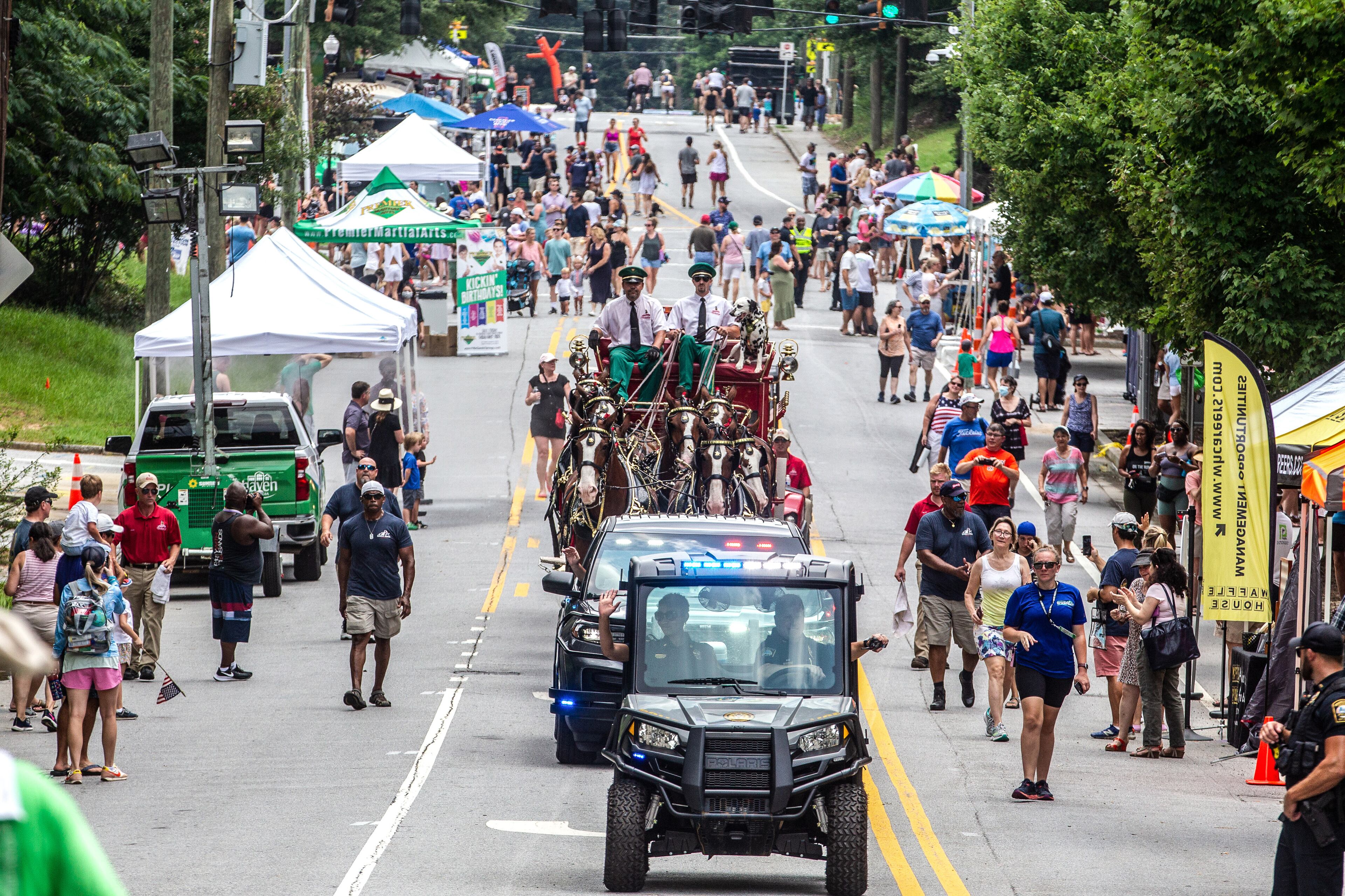 The Budweiser Clydesdales pull a cart along Dresden Drive during the Brookhaven Cherry Blossom Festival on Saturday, July 31, 2021.STEVE SCHAEFER FOR THE ATLANTA JOURNAL-CONSTITUTION