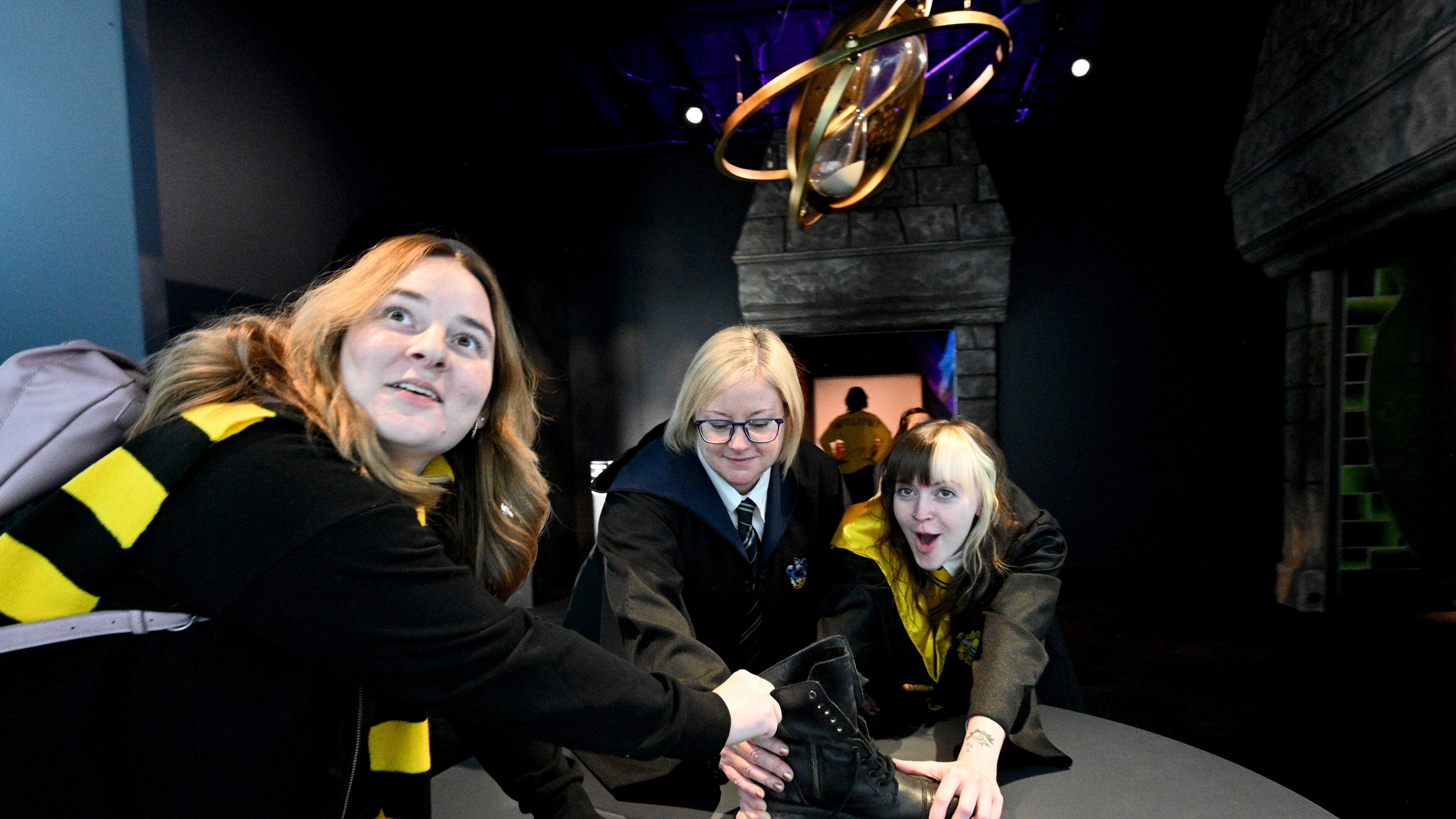 October 21, 2022 Atlanta - Harry Potter fans (from left) Alyssa Burgess, Jessica Simon and her daughter Sunshine Patterson react as they enjoy authentic props, costumes, and interactive technology at 200 Peachtree Street in downtown Atlanta on Friday, October 21, 2022. Created by Atlanta-based Imagine Exhibitions, “Harry Potter: The Exhibition” will take place at 200 Peachtree St. where Macy’s used to be located. (Hyosub Shin / Hyosub.Shin@ajc.com)