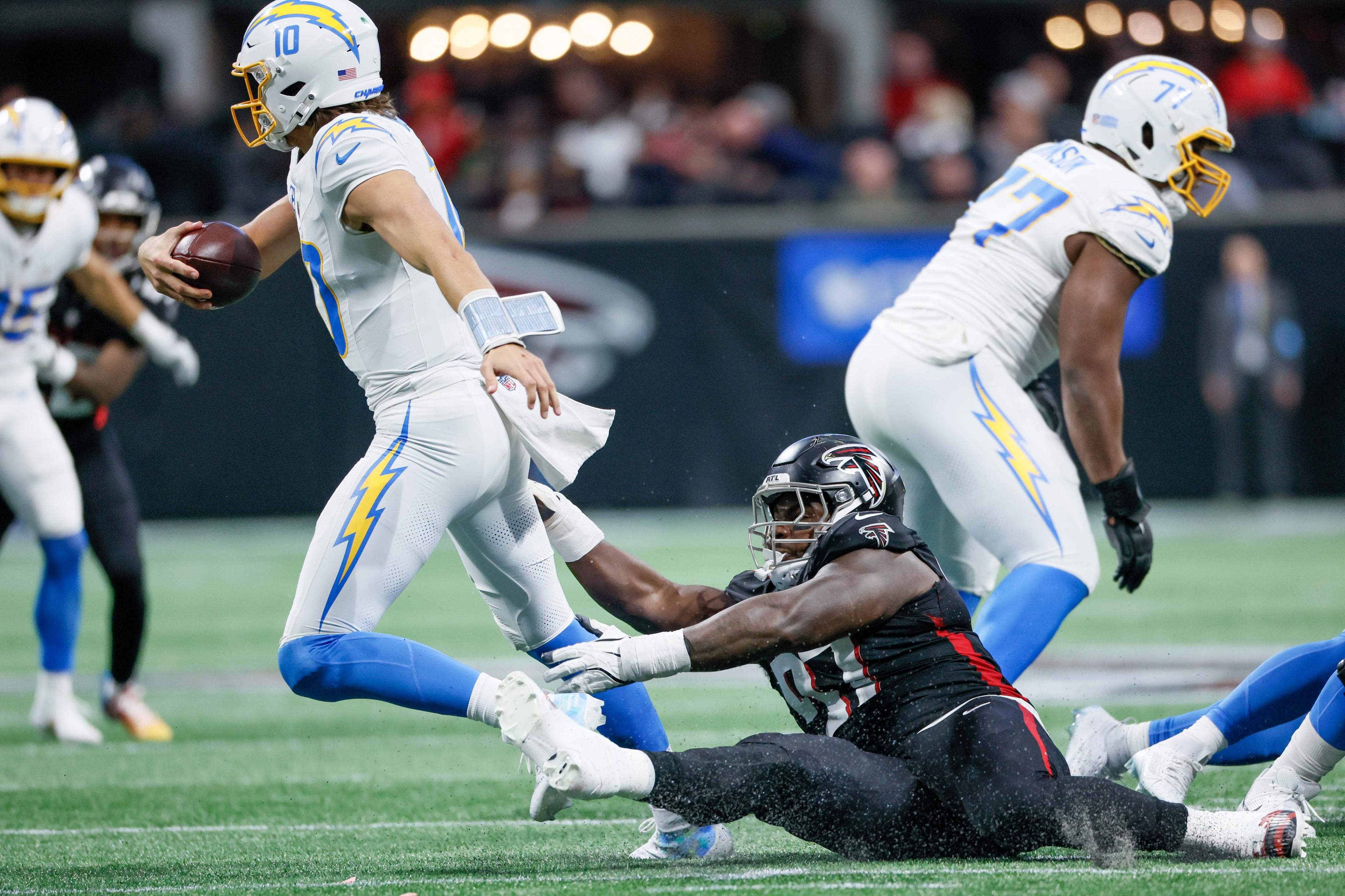 Atlanta Falcons defensive end Grady Jarrett (97) grabs Los Angeles Chargers quarterback Justin Herbert (10) as he escapes a sack during the second half of an NFL football game on Sunday, Dec. 1, 2024, at Mercedes-Benz Stadium in Atlanta.Â
(Miguel Martinez/ AJC)