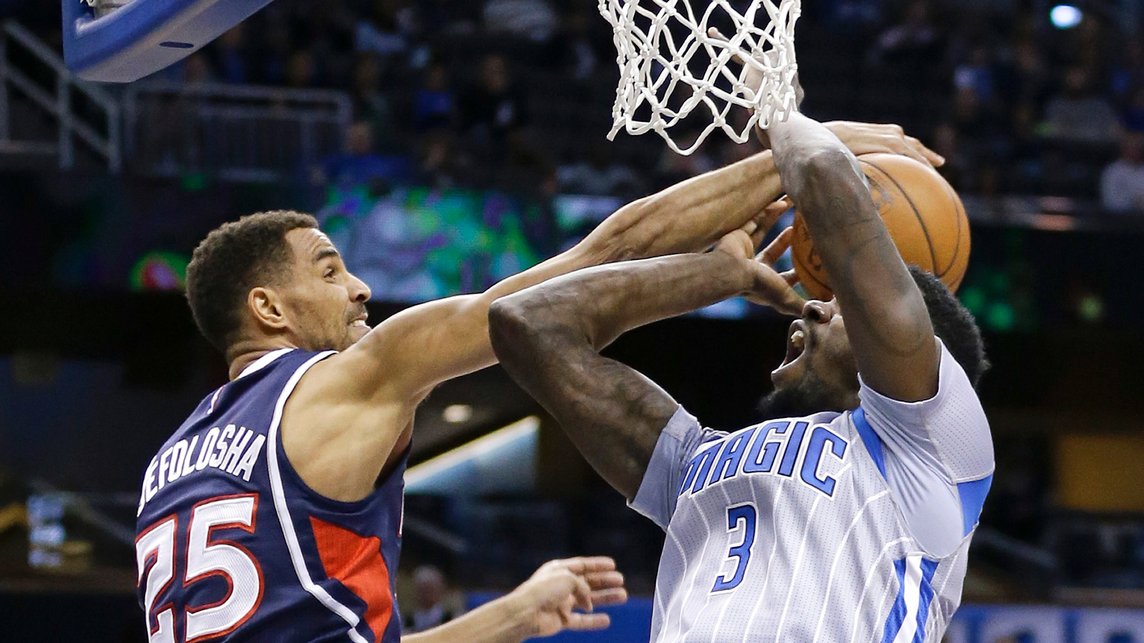 Atlanta Hawks' Thabo Sefolosha (25) blocks a shot attempt by Orlando Magic's Dewayne Dedmon (3) during the first half of an NBA basketball game, Saturday, Dec. 13, 2014, in Orlando, Fla. (AP Photo/John Raoux)