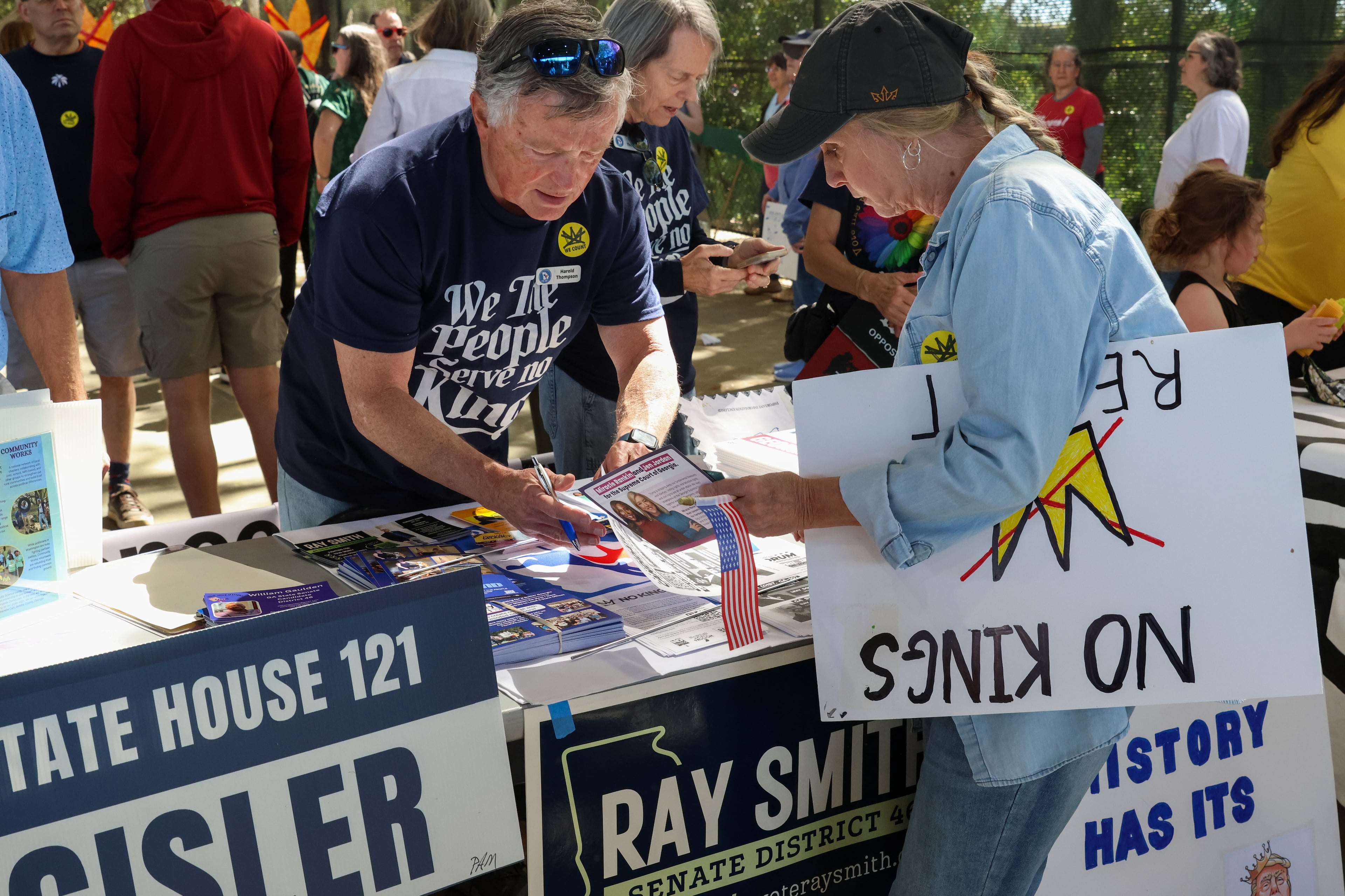 People share information during a “Democracy Fair” at Bishop Park in Athens on Saturday, March 28, 2026. Protesters gathered in 10 different locations around Georgia’s Congressional District 10, leading up to a rally at Bishop Park as part of a nationwide day of “No Kings” demonstrations. Organizers estimate that a few thousand people participated, many of them first-time protesters. (C.J. Bartunek for the AJC)