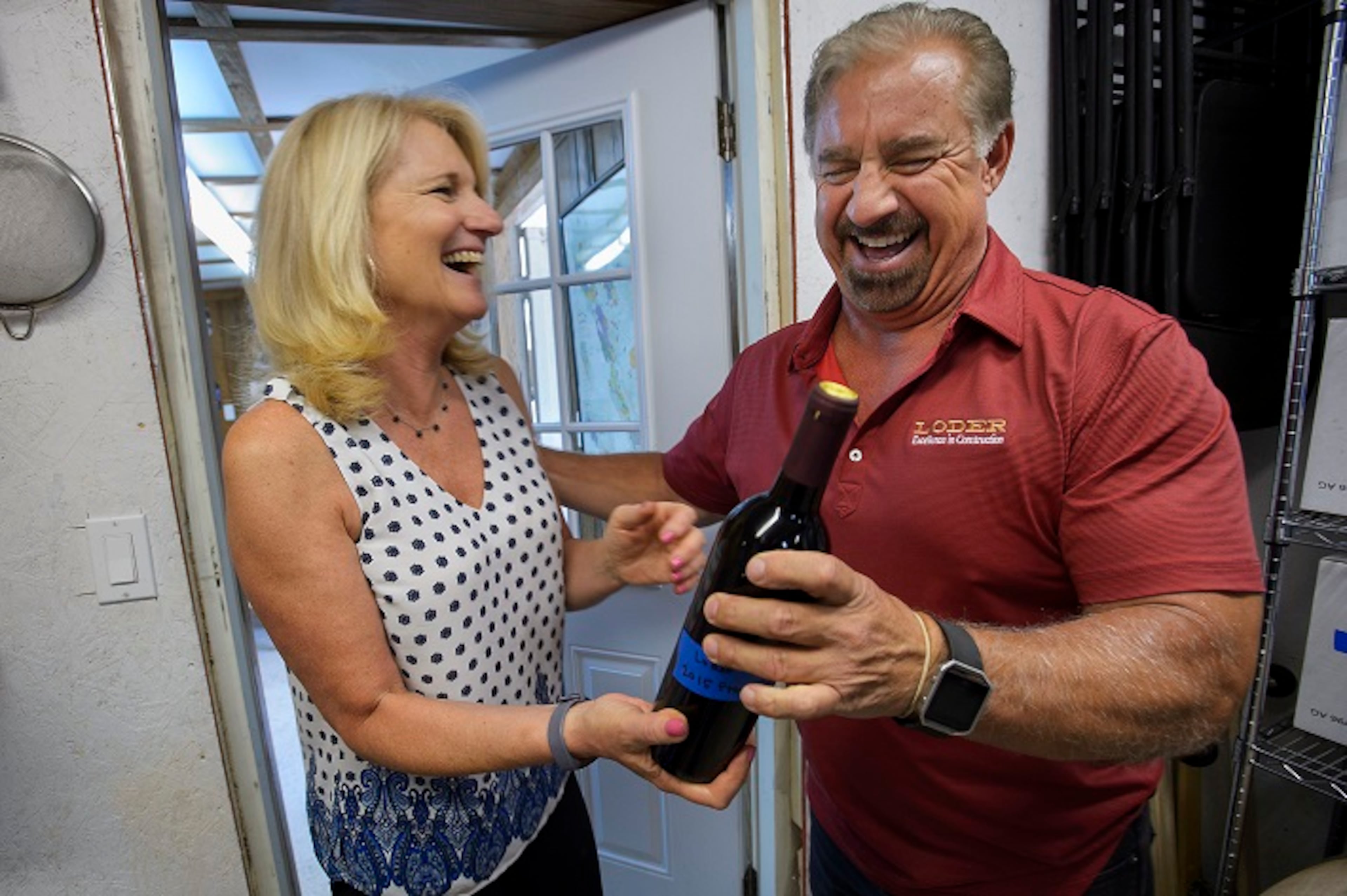 Kathy Loder, left, and her husband, Ron Loder, with a bottle of their wine at their home winery in Granite Bay, Calif., on July 26, 2017. (Randall Benton/Sacramento Bee/TNS)