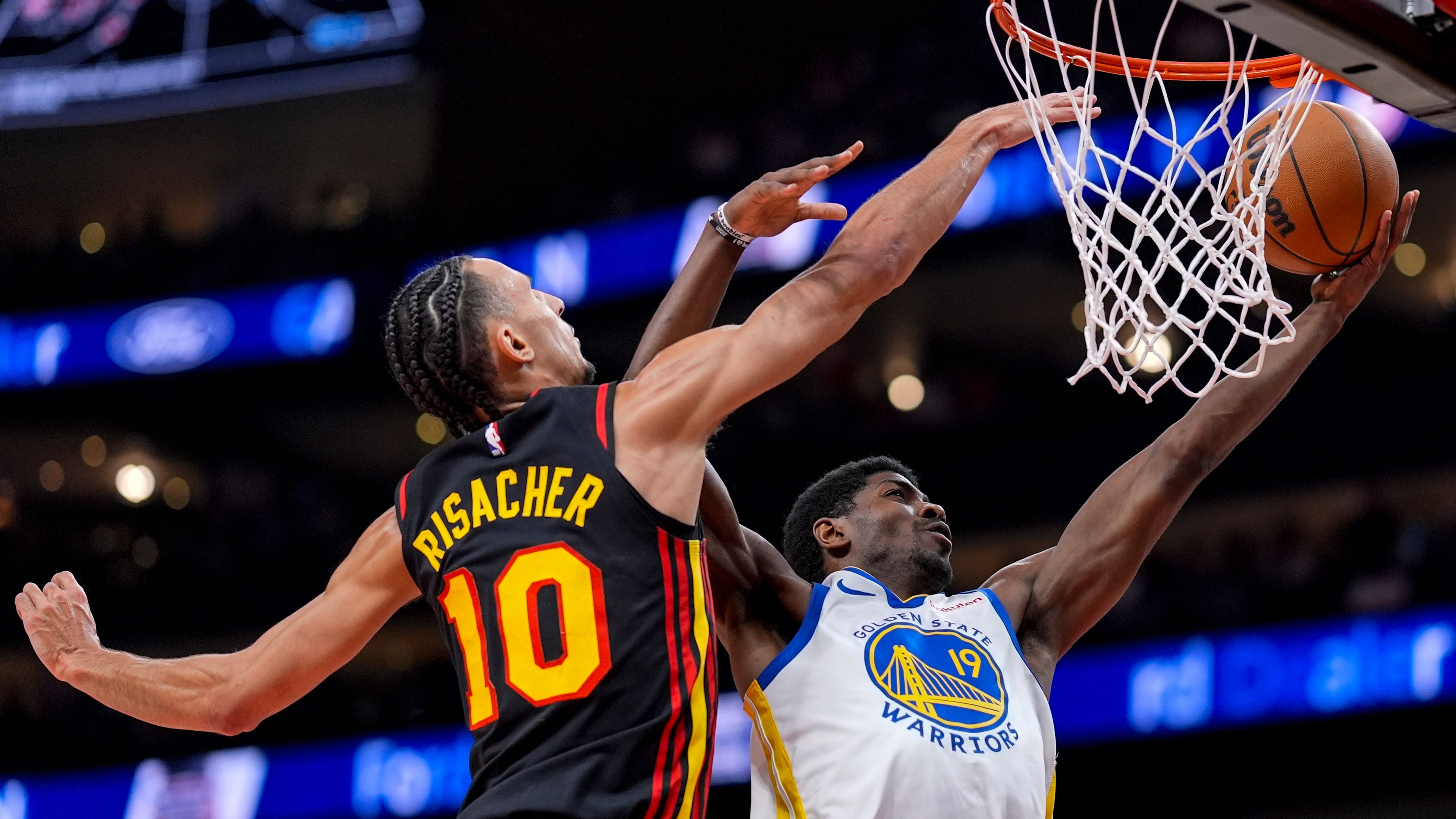 Warriors guard Nate Williams (19) shoots over Hawks forward Zaccharie Risacher during the first half Saturday, March 21, 2026, in Atlanta. Risacher scored 17 points off the bench. (Mike Stewart/AP)