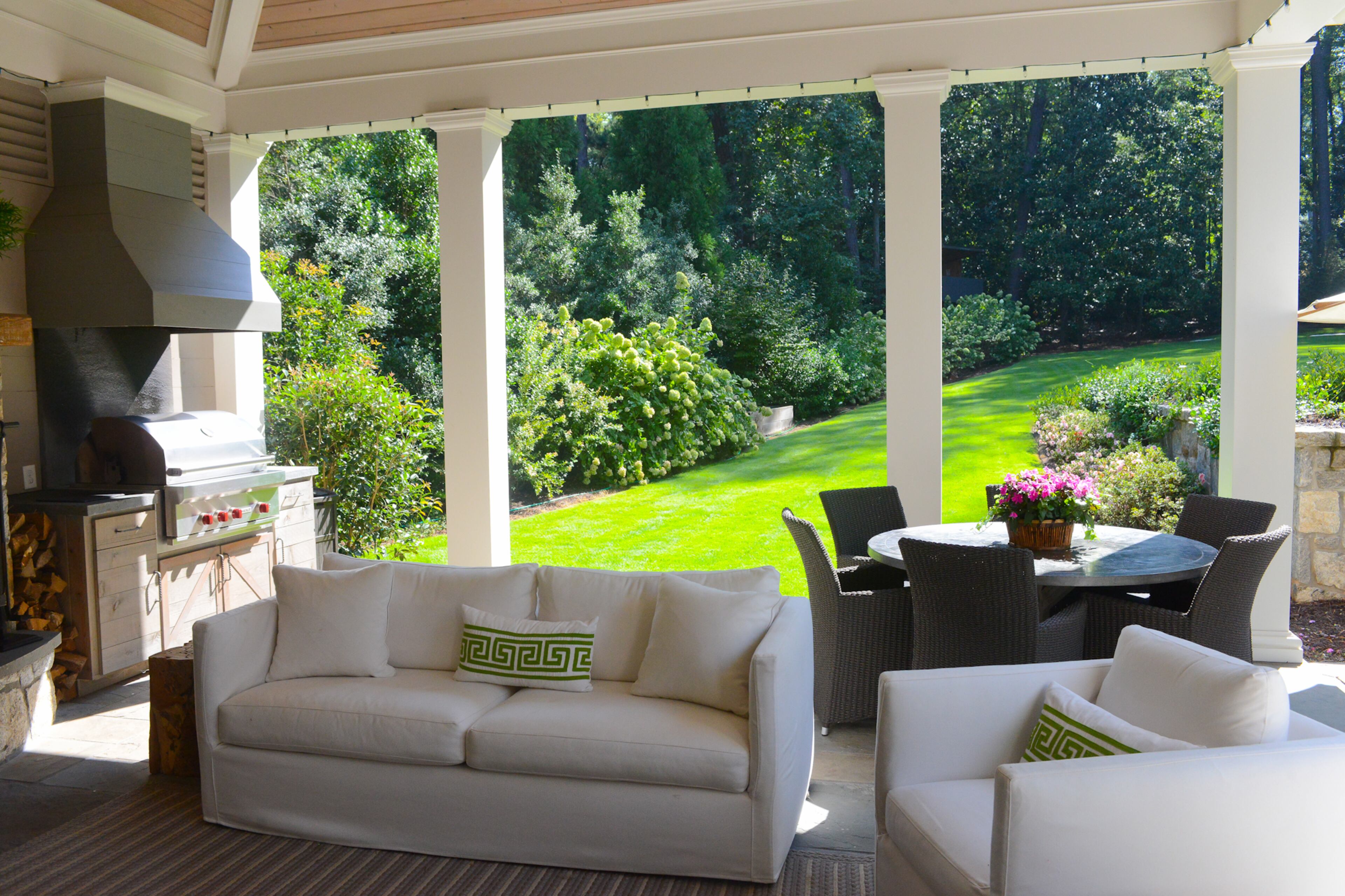 The covered porch, with an outdoor kitchen and dining areas, opens to their lush 1-acre yard, complete with pool and a treehouse.