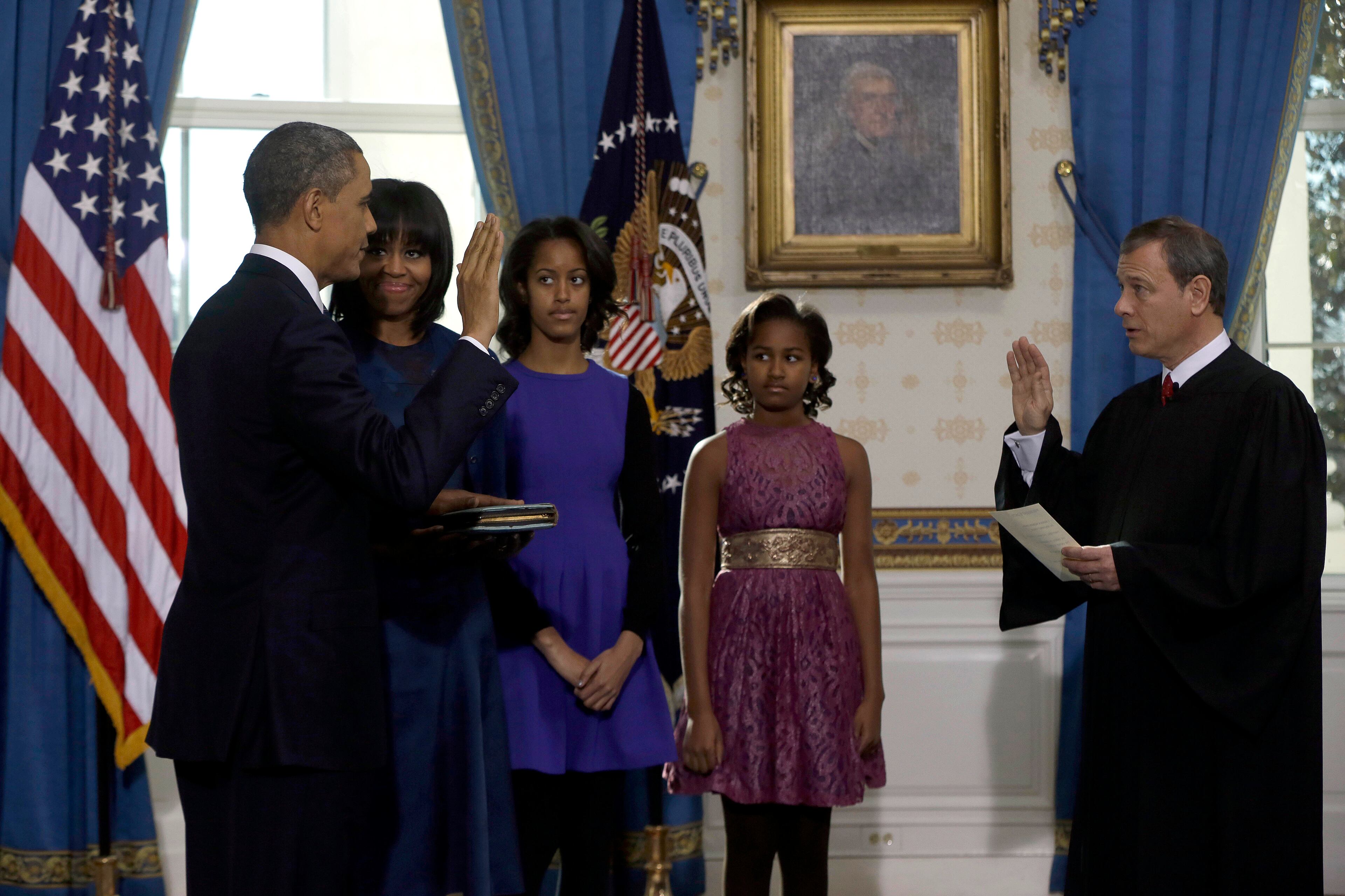 The first lady and daughter Malia matched President Barack Obama's blue suit, also complementing the Blue Room of the White House, where the small ceremony took place. Younger daughter Sasha, however, went her own way: She wore a lacy pink dress with a gold, wide-width, high-waisted belt , a style her mother helped popularize , and gold shoes.