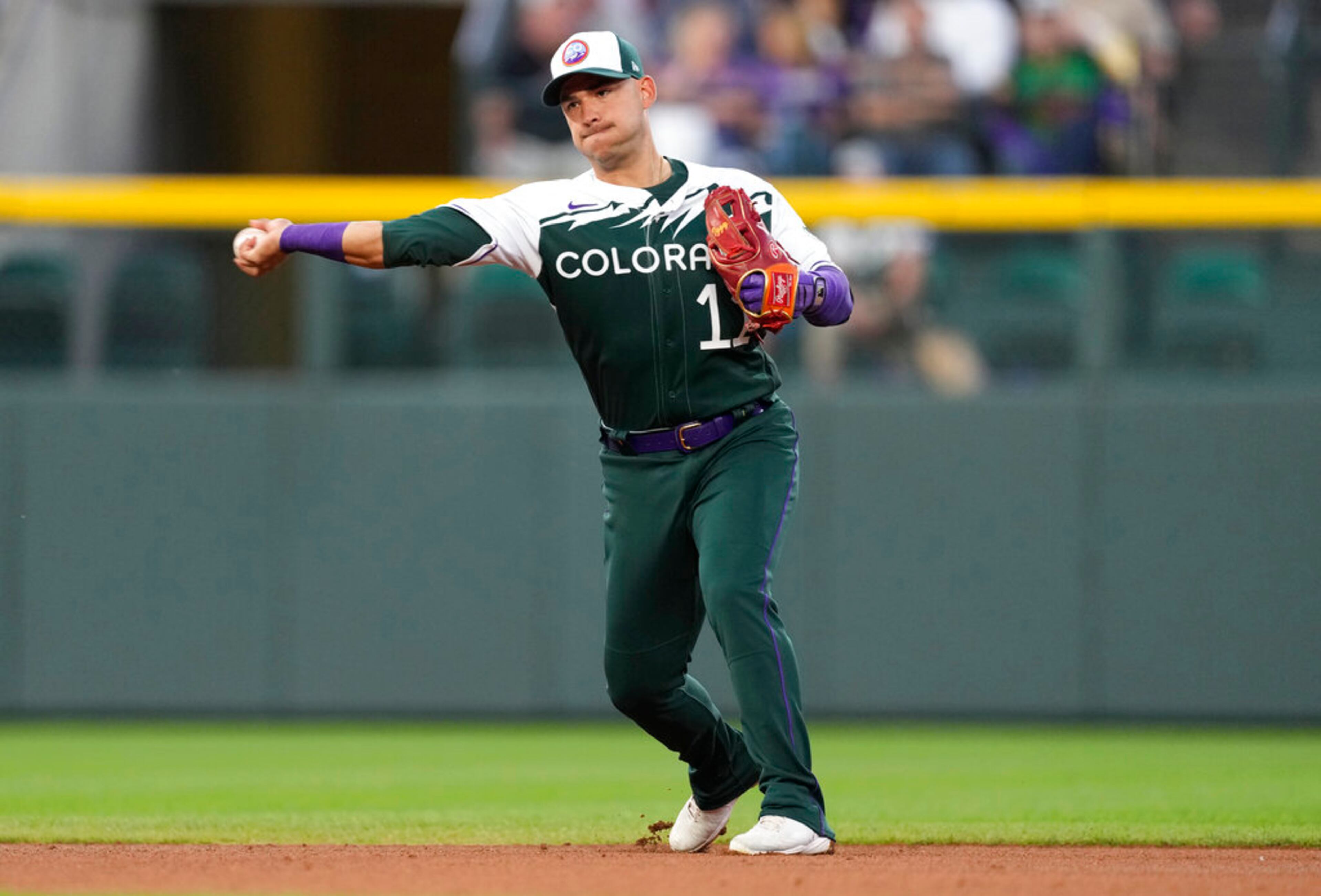 Colorado Rockies shortstop Jose Iglesias throws to first base after fielding a ball hit by Atlanta Braves' Austin Riley in the fourth inning of a baseball game Saturday, June 4, 2022, in Denver. Iglesias was charged with a throwing error on the play. (AP Photo/David Zalubowski)