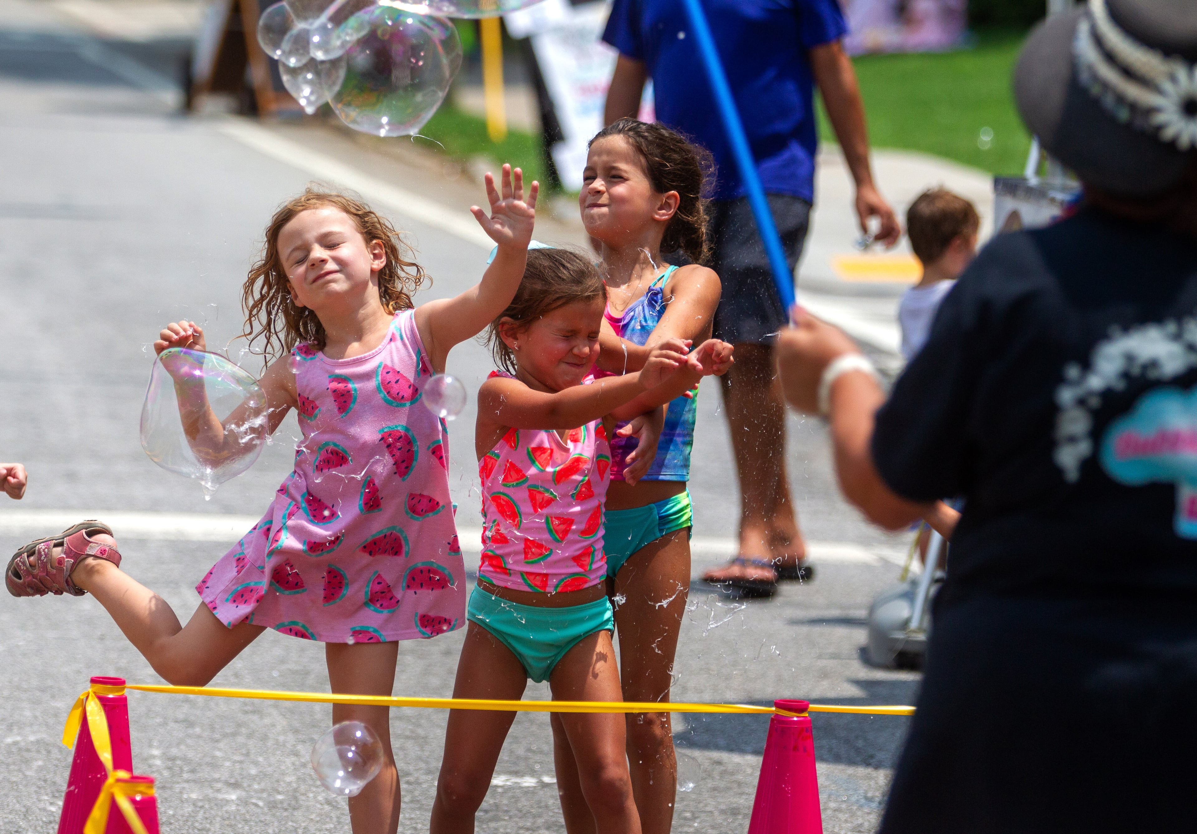 Kids pop large bubbles created by Deborah Mosher during the Brookhaven Cherry Blossom Festival on Saturday, July 31, 2021. STEVE SCHAEFER FOR THE ATLANTA JOURNAL-CONSTITUTION