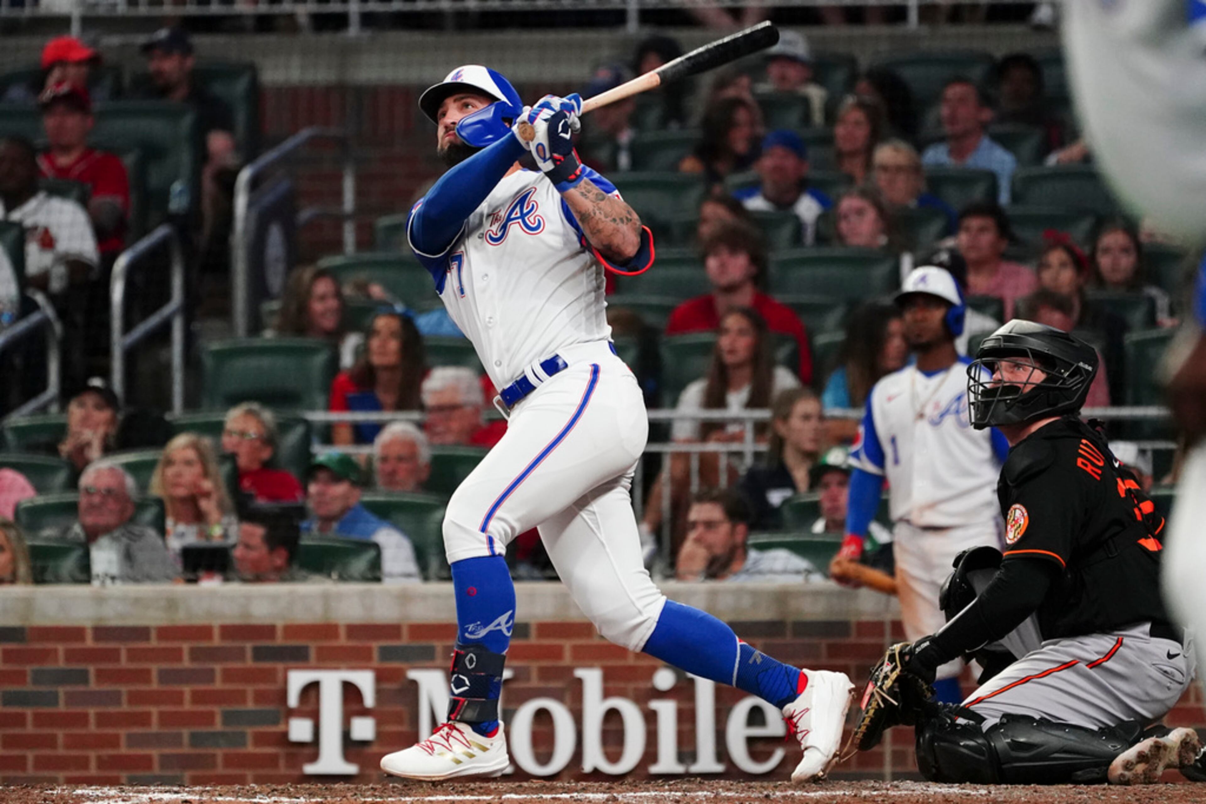 Atlanta Braves pinch hitter Kevin Pillar, left, puts his team ahead with a two-run home run as Baltimore Orioles catcher Adley Rutschman, right, looks on in the eighth inning of a baseball game Saturday, May 6, 2023, in Atlanta. The Braves won 5-4. (AP Photo/John Bazemore)