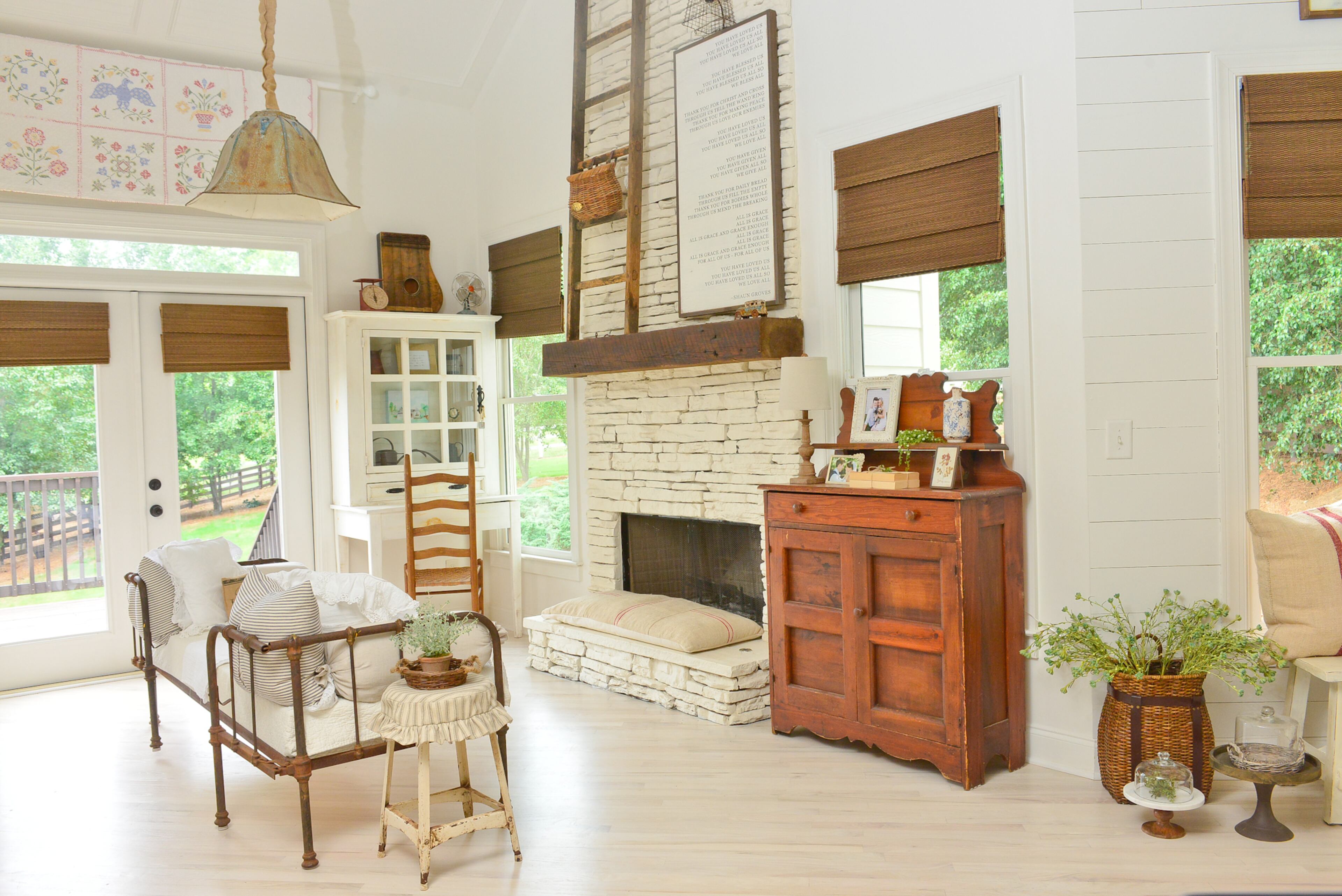 In the keeping room is an antique child's bed, which homeowner Wendy Durnwald found at an antiques store and uses as a seating area. Smaller than a twin but bigger than a crib, this kind of bed is an extremely rare find. Durnwald left it rusted and looking aged, and added a thick piece of foam and vintage pillows to make a cozy place to sit in front of the painted stone fireplace.