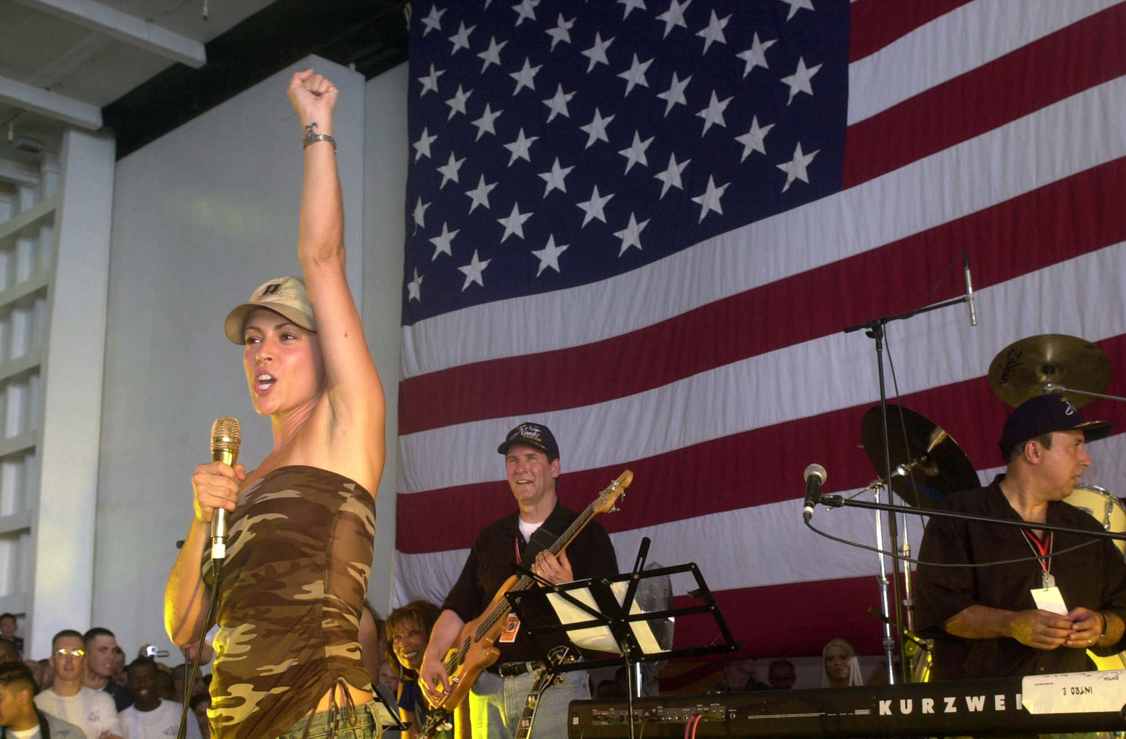 Actress Alyssa Milano speaks to troops during a United Services Organization (USO) show aboard USS Nimitz June 19, 2002 in the Arabian Gulf. (Photo by Sandra Palumbo/U.S. Navy/Getty Images)