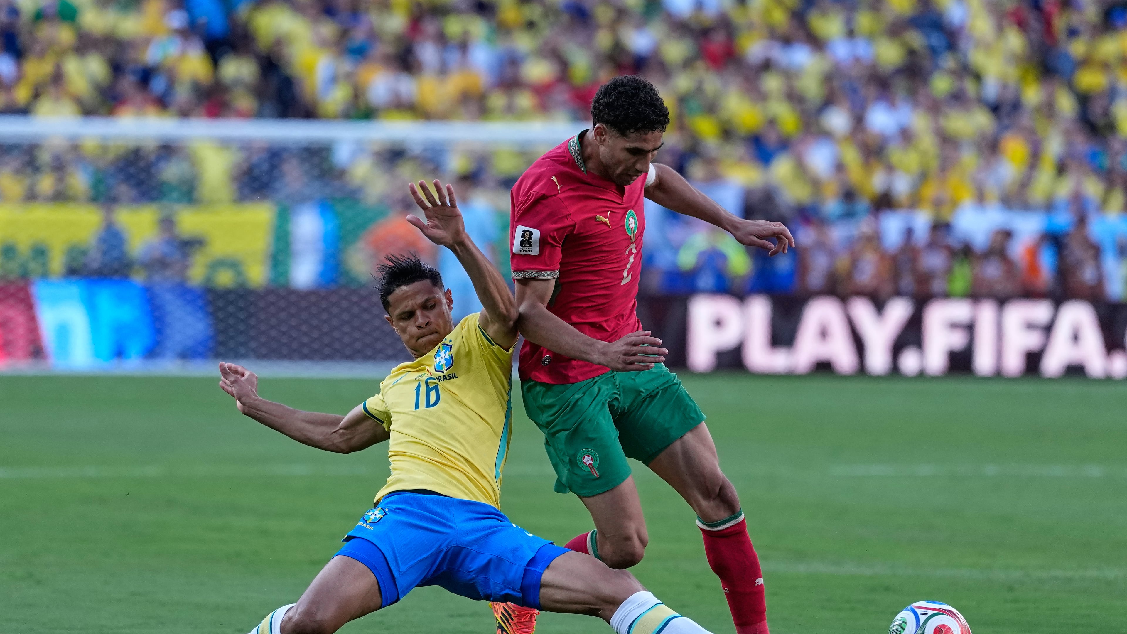 Brazil's Douglas Santos, left, challenges Morocco's Achraf Hakimi during the World Cup Group C soccer match between Brazil and Morocco in East Rutherford, N.J., near New York, Saturday, June 13, 2026. (AP Photo/Petr David Josek)
