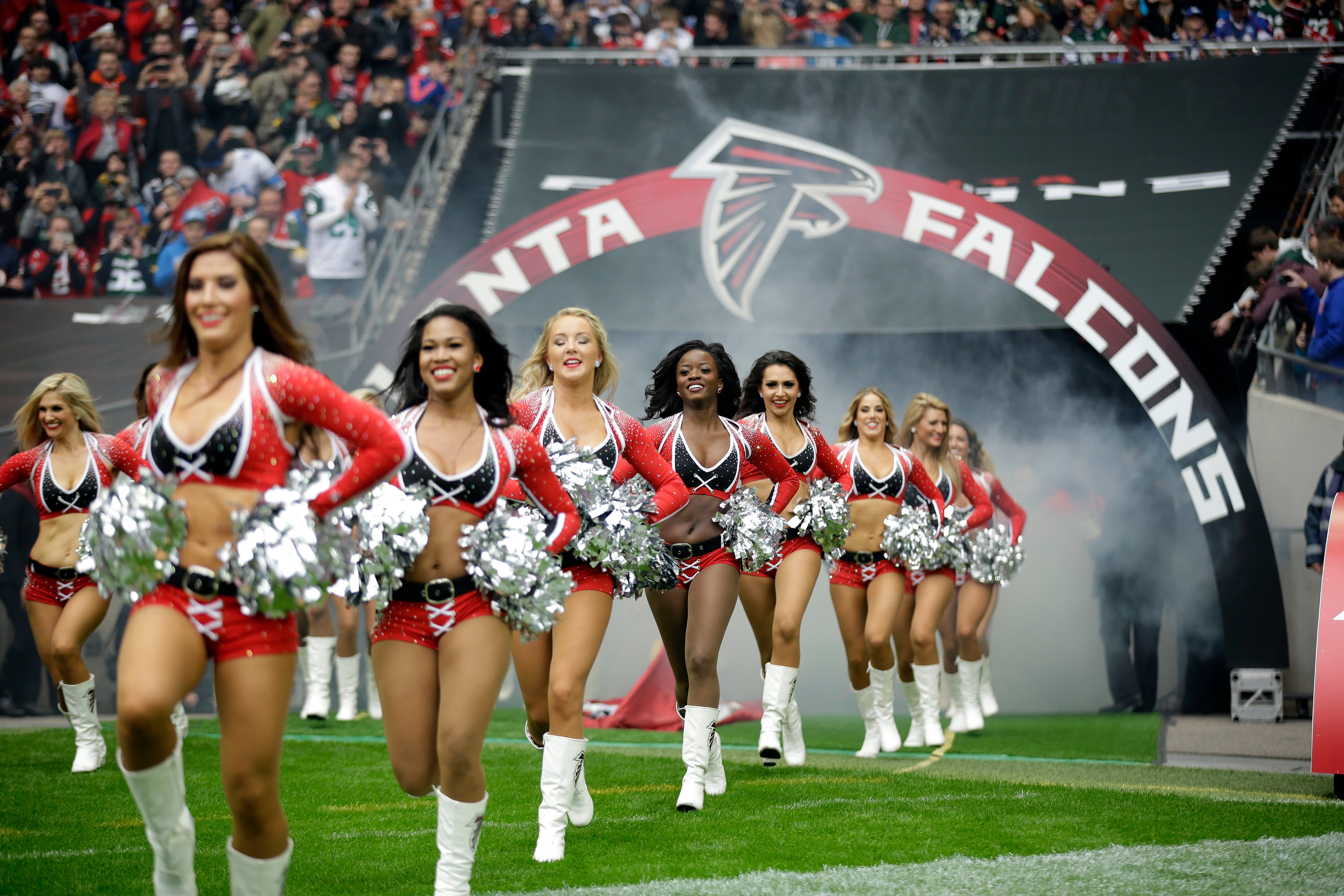 Atlanta Falcons cheerleaders run to the field before the NFL football game between the Atlanta Falcons and the Detroit Lions at Wembley Stadium, London, Sunday, Oct. 26, 2014. (AP Photo/Matt Dunham)