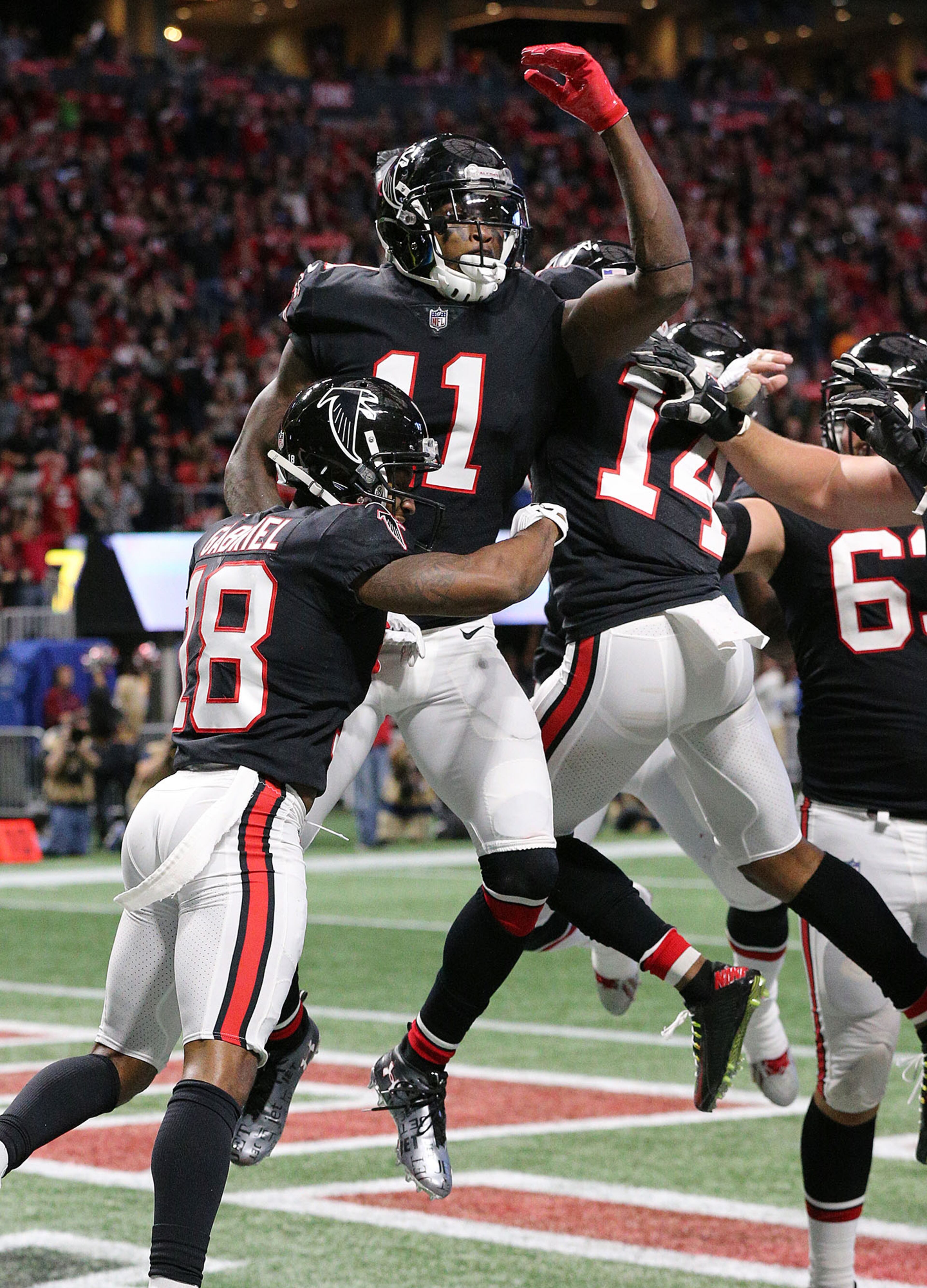 November 26, 2017 Atlanta: Falcons wide receiver Julio Jones celebrates his touchdown catch with Taylor Gabriel and Justin Hardy on a pass from wide receiver Mohamed Sanu during a trick play to take a 10-3 lead during the second quarter in a NFL football game on Sunday, November 26, 2017, in Atlanta. Jones caught two touchdown passes in the second quarter. Curtis Compton/ccompton@ajc.com