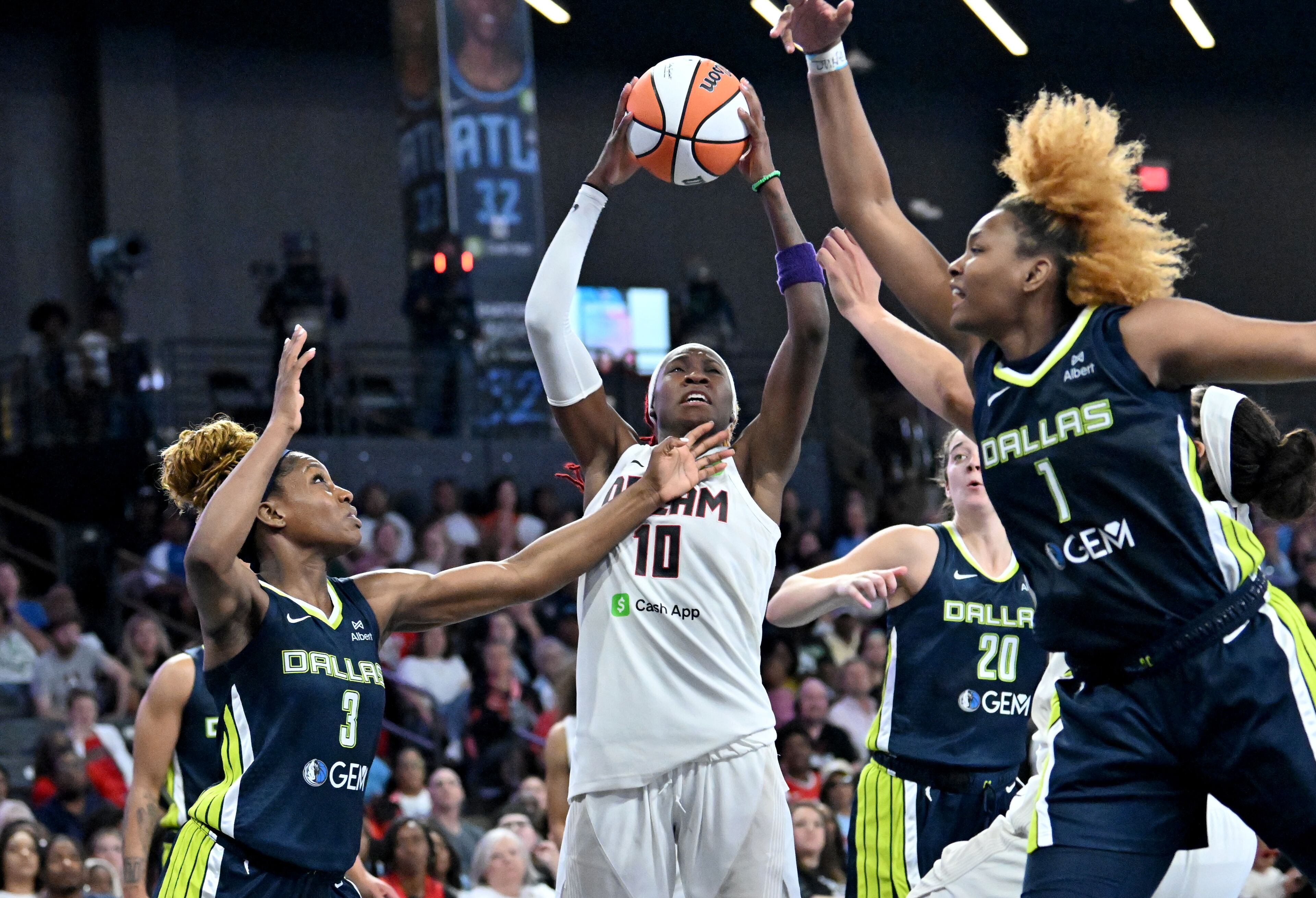 Atlanta Dream guard Rhyne Howard (10) prepares to shoot against Dallas Wings guard Kaila Charles (3) and Dallas Wings forward NaLyssa Smith (1) during the second half in a WNBA basketball game at Gateway Center Arena, Saturday, May 24, 2025, in Atlanta. Atlanta Dream won 83-75 over Dallas Wings. (Hyosub Shin / AJC)