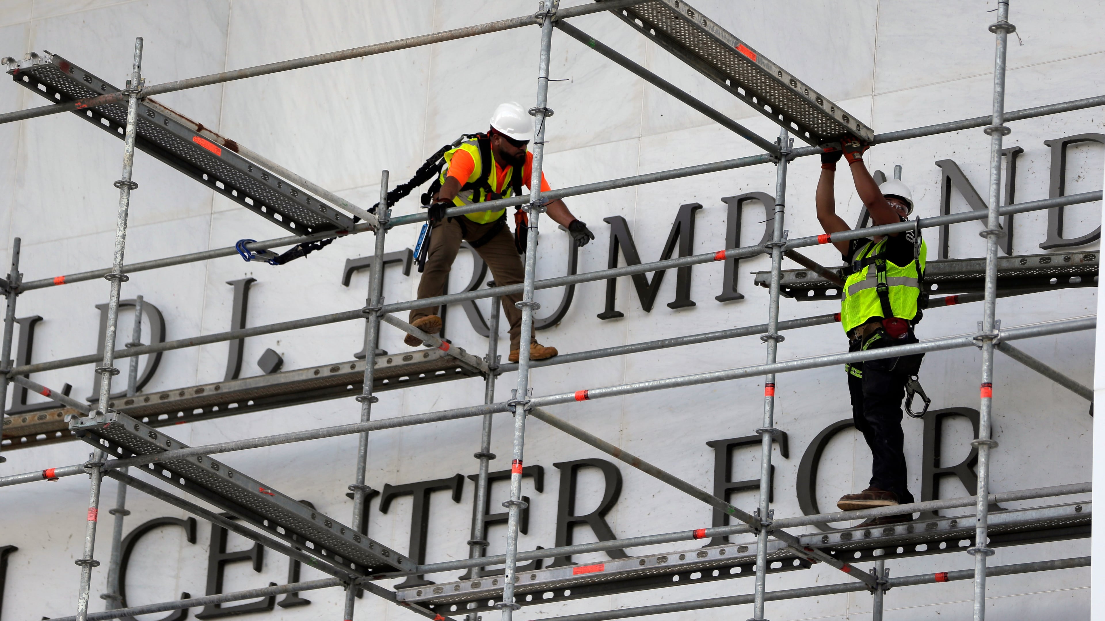 Workers construct scaffolding at the sign for the John F. Kennedy Center for the Performing Arts, Friday, June 12, 2026, in Washington. (AP Photo/Rahmat Gul)