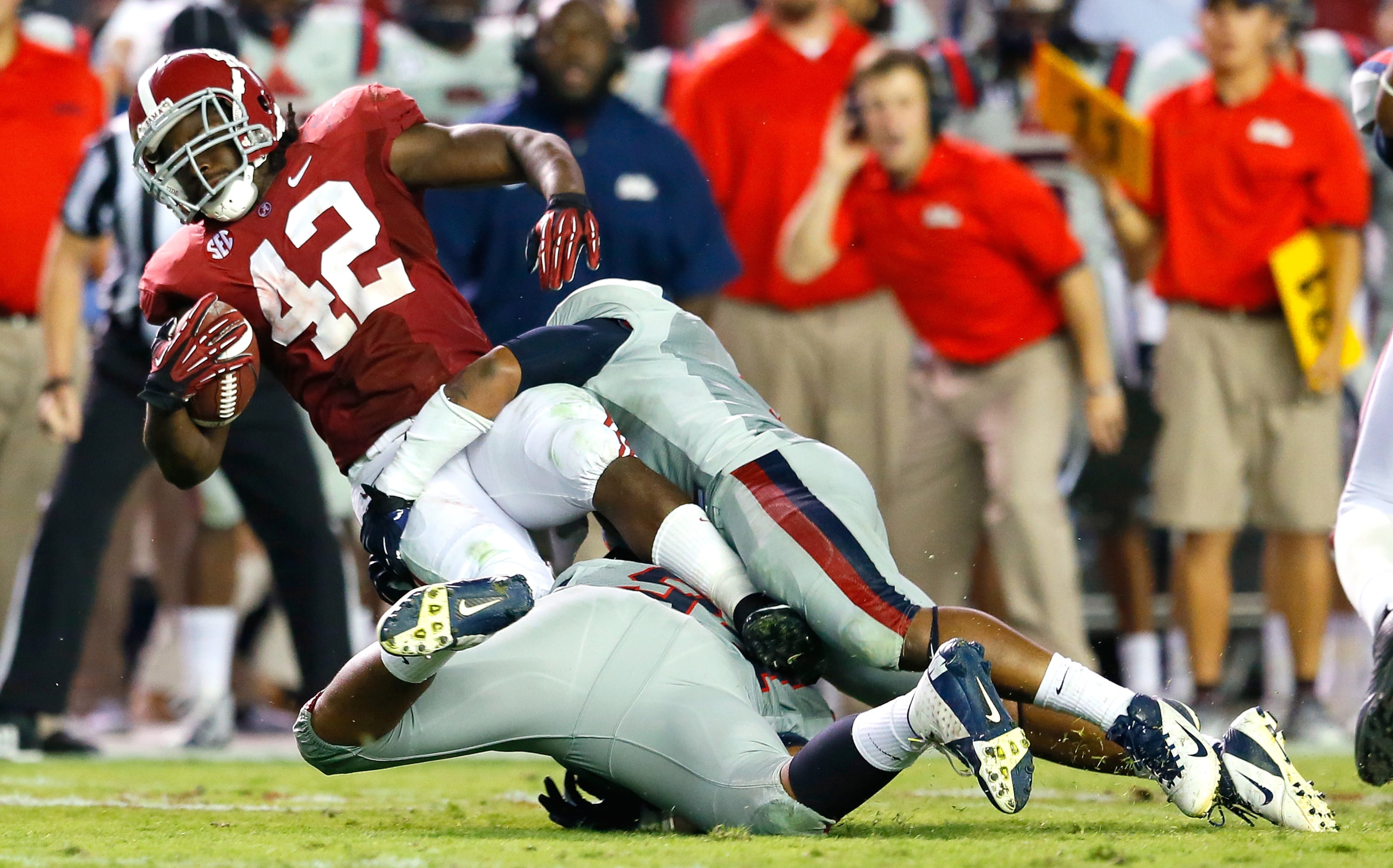 Issac Gross (94) and Denzel Nkemdiche (4) of the Mississippi Rebels tackle Eddie Lacy (42) of the Alabama Crimson Tide at Bryant-Denny Stadium on September 29, 2012 in Tuscaloosa, Alabama.