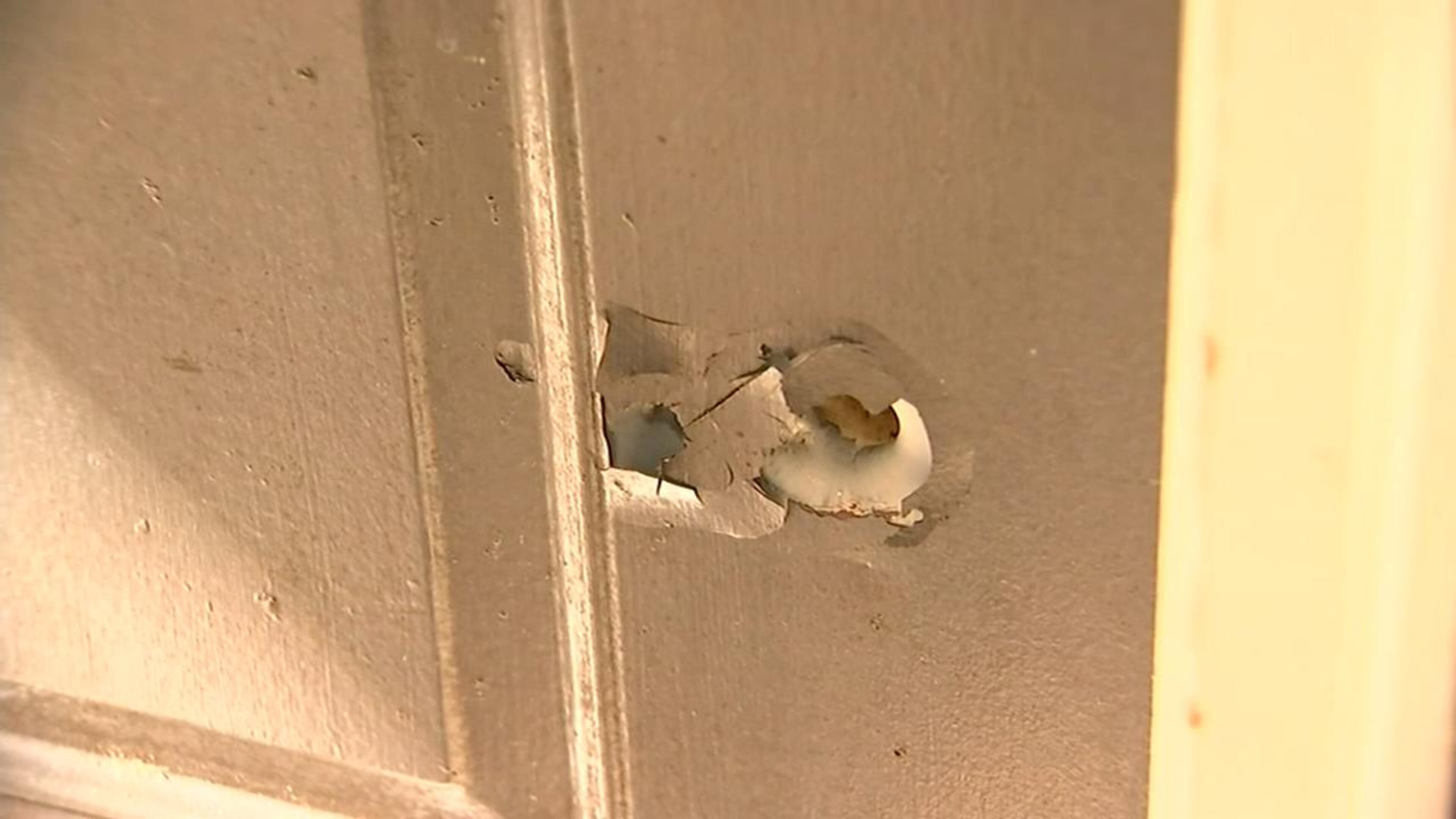 A bullet hole left in a neighbor’s door after a gun fired while the owner was cleaning it. (Credit: Channel 2 Action News)