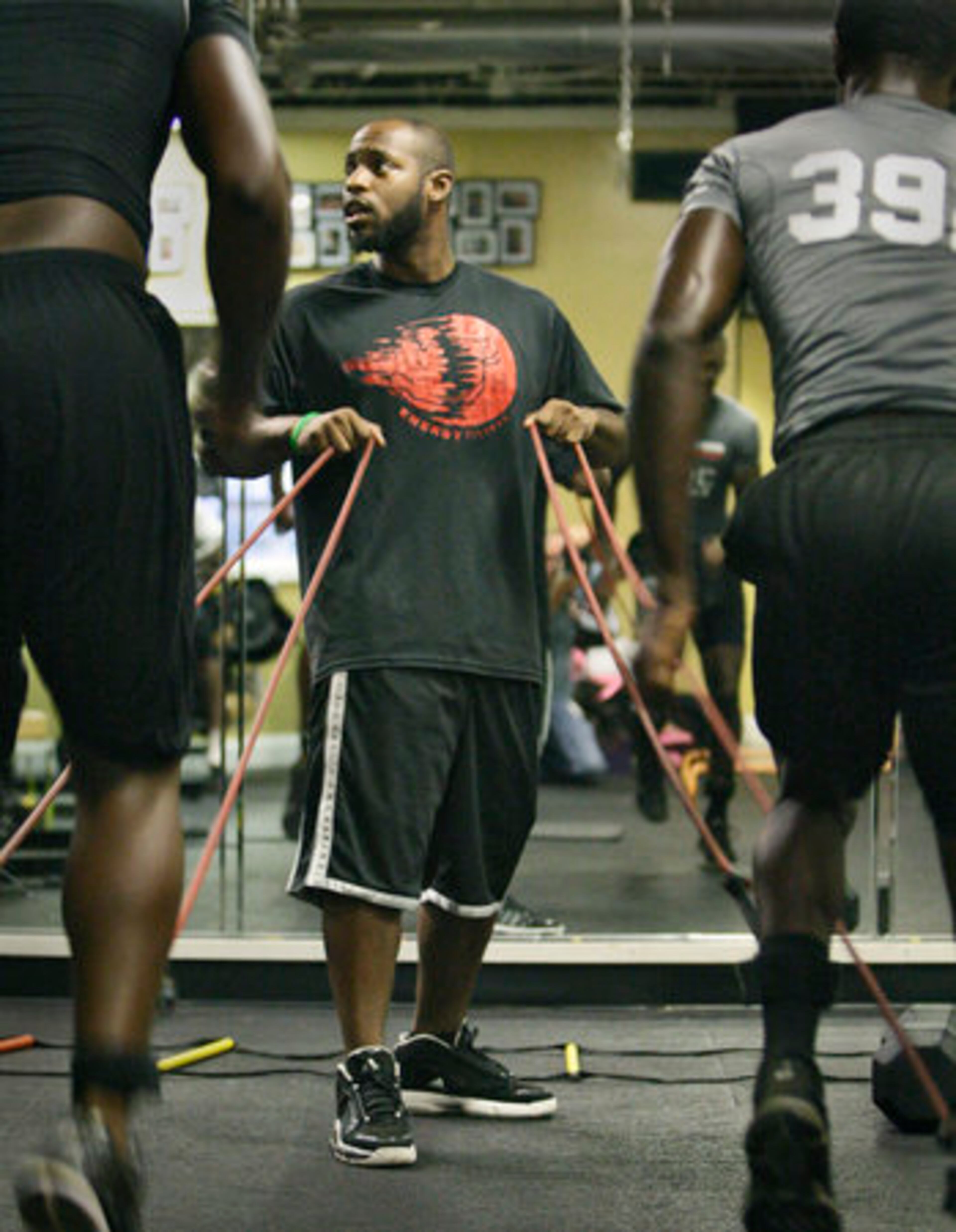Jay Nears runs Quinteze Williams and Ronnie Harris II (l to r) through a training session at Energy Fitness Center.