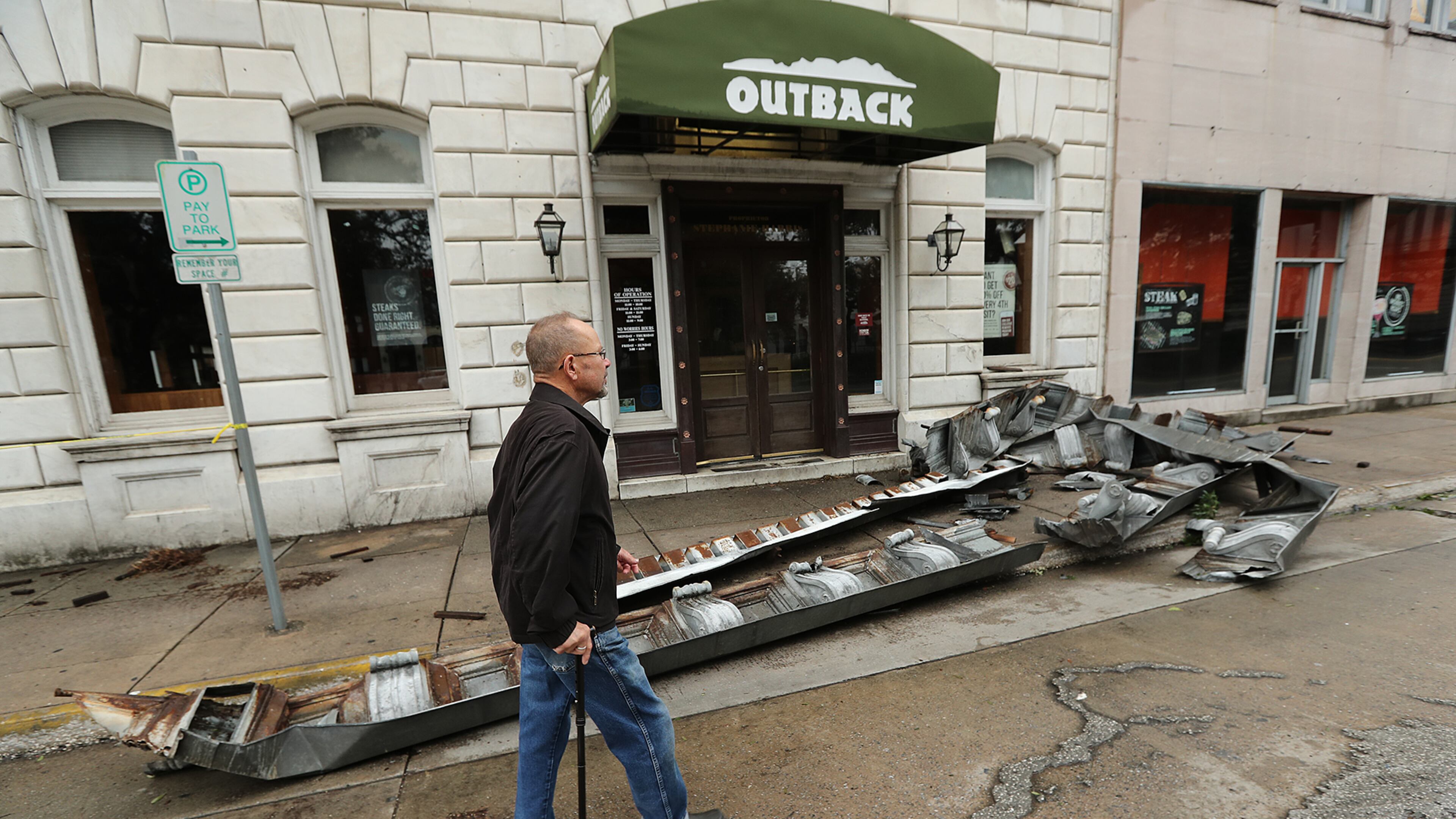 SAVANNAH: A man walks past debris from a damaged building in historic downtown Savannah in the aftermath of Hurricane Matthew on Saturday, Oct. 8, 2016. Curtis Compton /ccompton@ajc.com