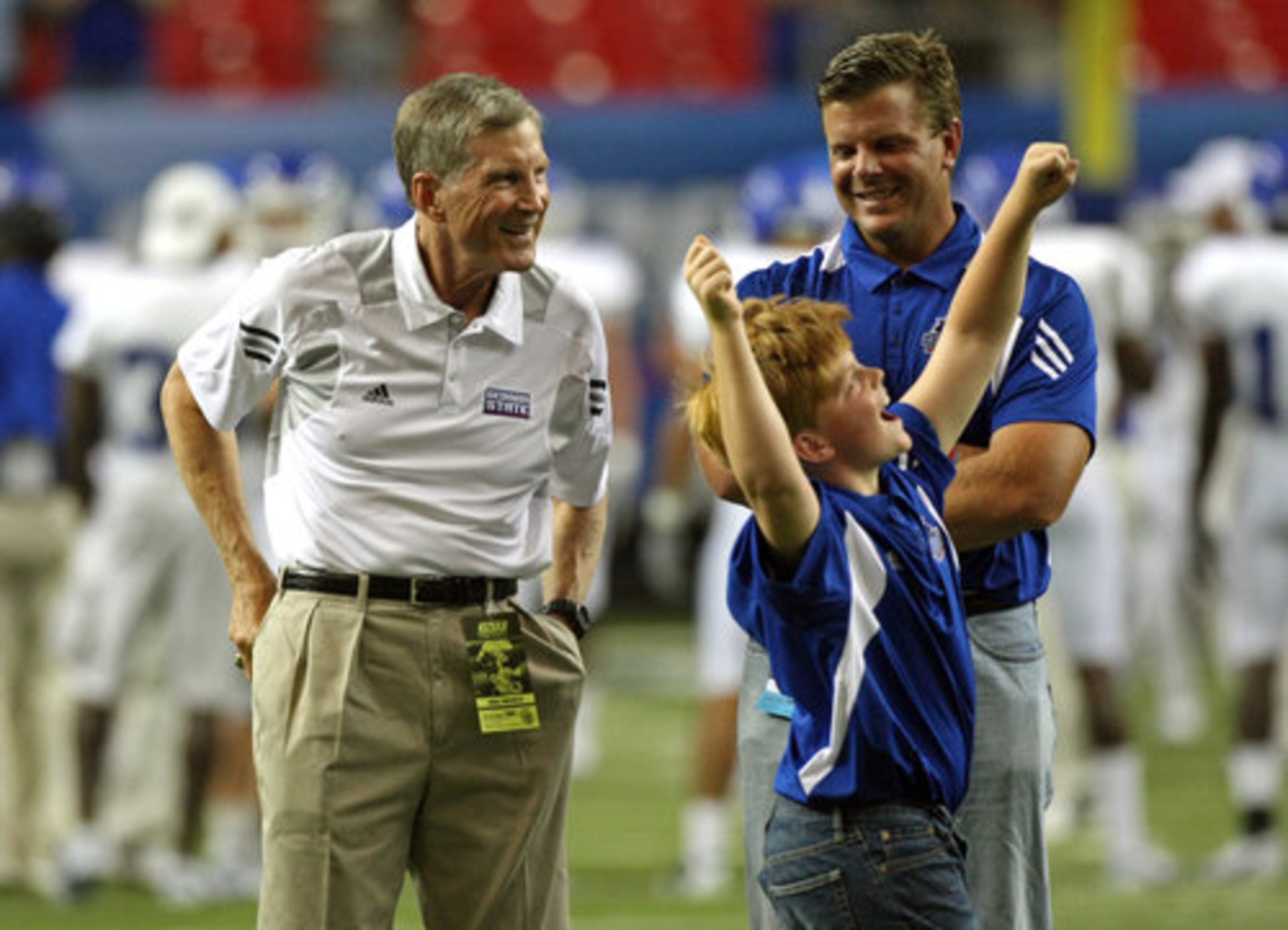 GSU coach Bill Curry, left, stands with his son Bill Curry Jr. and grandson Elliot Curry, 11, as Elliot shows his enthusiasm before their inaugural game against Shorter College in the Georgia Dome Thursday night in Atlanta, Ga., Sept. 2, 2010.