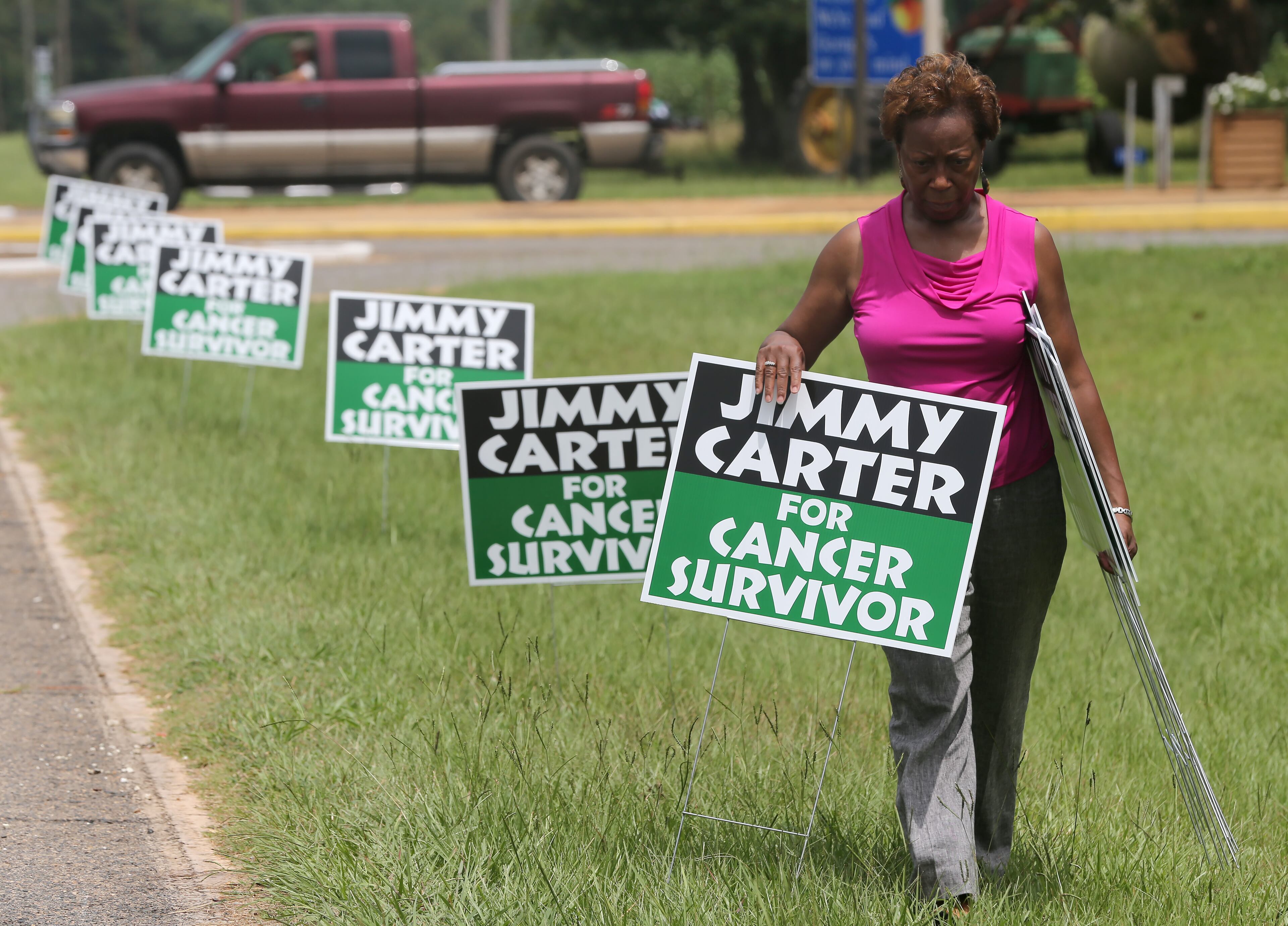 State Sen. Freddie Powell Sims (D-Dawson) places "Jimmy Carter for Cancer Survivor" signs along the road leading into Plains on Thursday afternoon August 20, 2015 in advance of the President's return to his hometown. Ben Gray / bgray@ajc.com