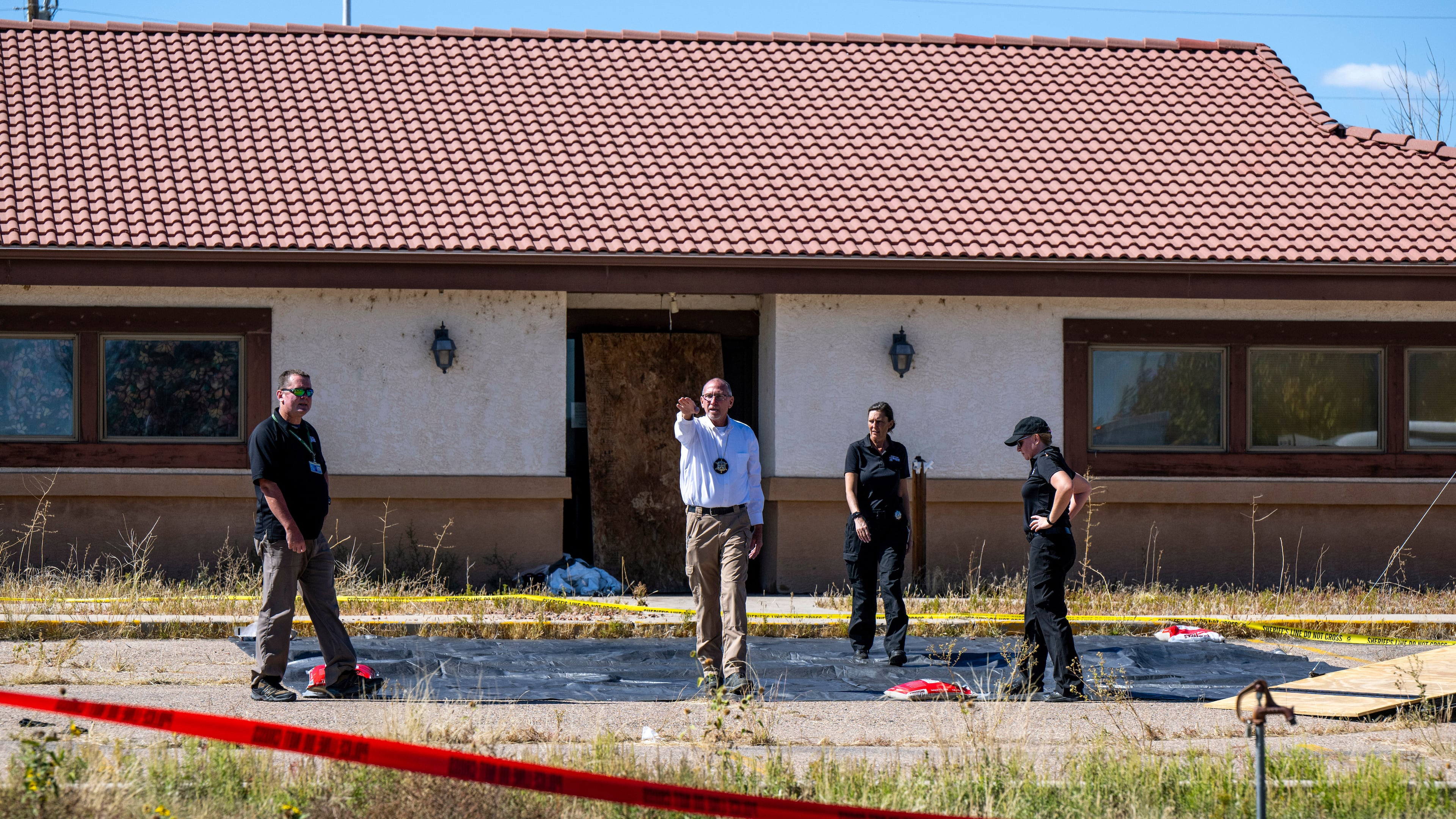 FILE - Fremont County coroner Randy Keller, center, and other authorities survey the area where they plan to put up tents at the Return to Nature Funeral Home where over 100 bodies have been improperly stored, Saturday, Oct. 7, 2023, in Penrose, Colo. (Parker Seibold/The Gazette via AP, File)/The Gazette via AP)